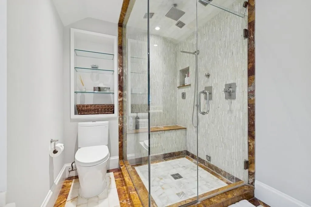 Full bathroom featuring baseboards, toilet, a shower stall, and vaulted ceiling Full bathroom featuring baseboards, toilet, a shower stall, and vaulted ceiling