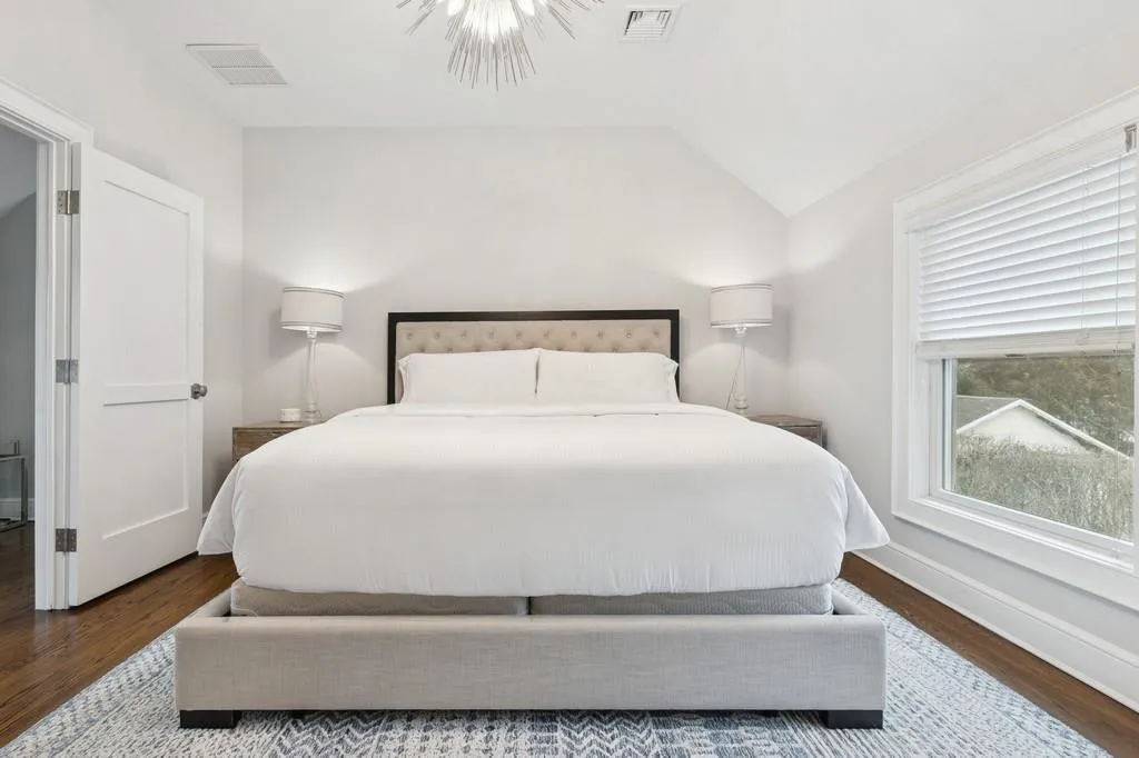 Bedroom with visible vents, wood finished floors, baseboards, and vaulted ceiling Bedroom with visible vents, wood finished floors, baseboards, and vaulted ceiling