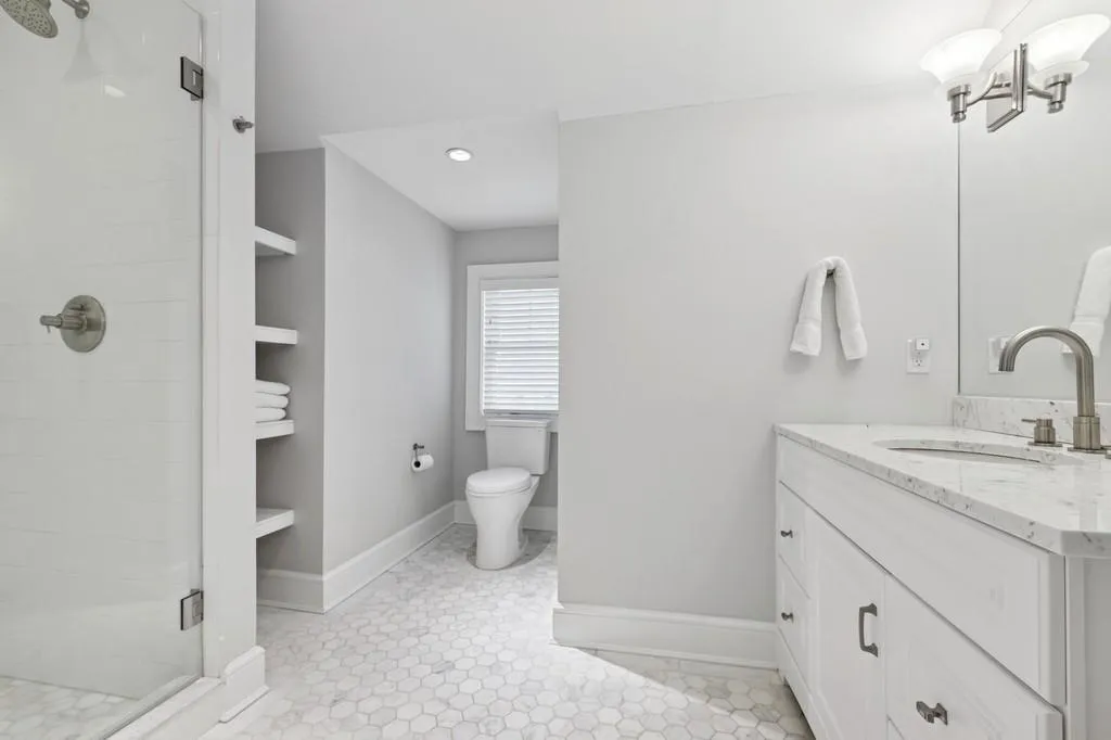 Full bath featuring vanity, a shower stall, toilet, and baseboards Full bath featuring vanity, a shower stall, toilet, and baseboards