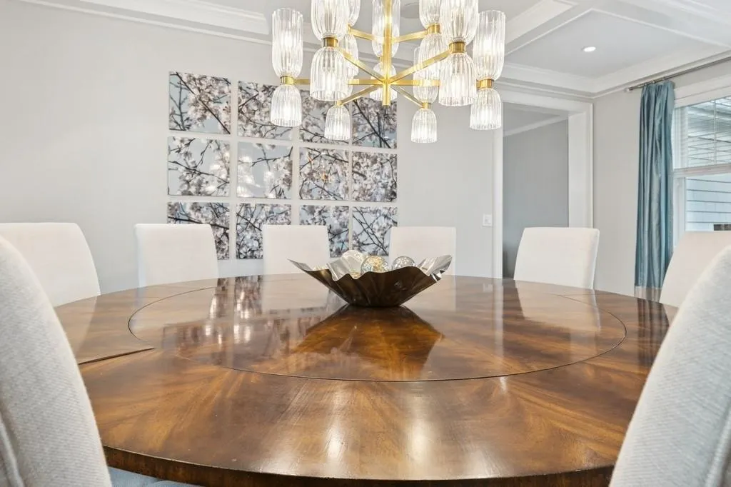 Dining area featuring beamed ceiling, a notable chandelier, crown molding, and coffered ceiling Dining area featuring beamed ceiling, a notable chandelier, crown molding, and coffered ceiling