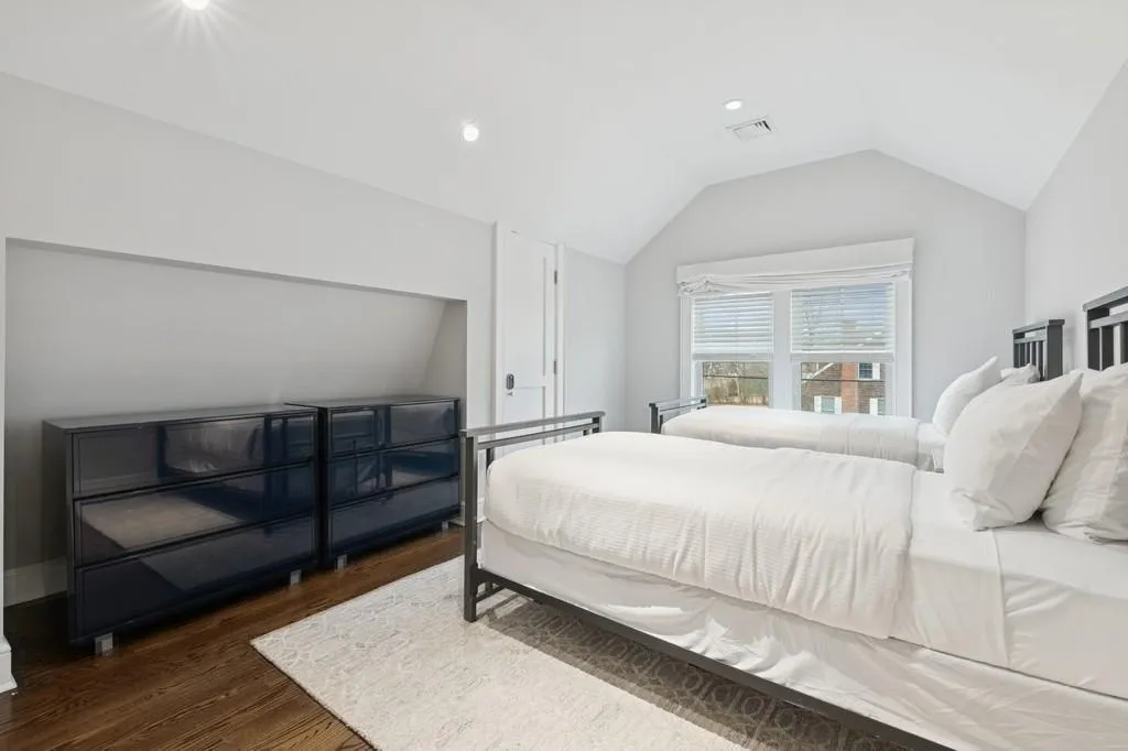 Bedroom with lofted ceiling, wood finished floors, and visible vents Bedroom with lofted ceiling, wood finished floors, and visible vents