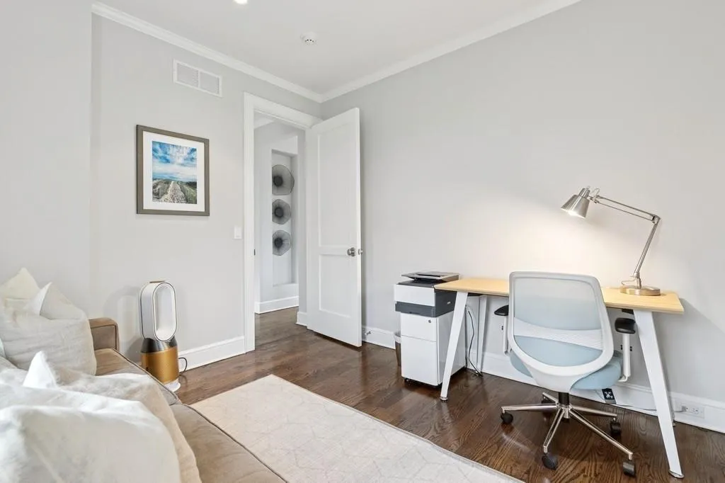 Office space with visible vents, crown molding, baseboards, and dark wood-style flooring Office space with visible vents, crown molding, baseboards, and dark wood-style flooring