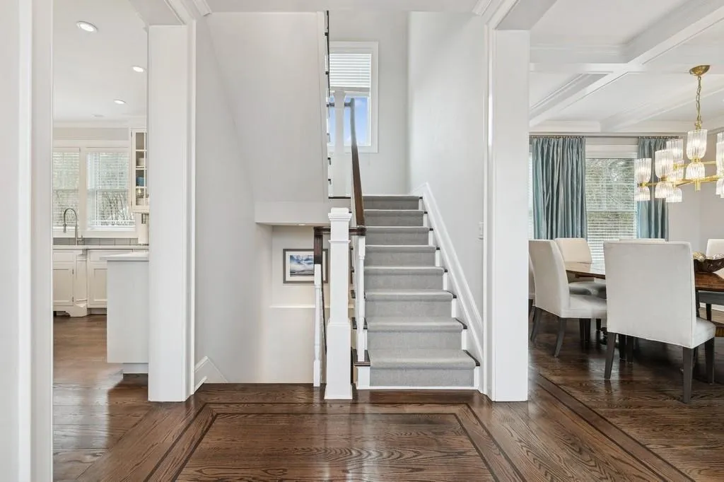 Stairs featuring wood finished floors, coffered ceiling, an inviting chandelier, ornamental molding, and beamed ceiling Stairs featuring wood finished floors, coffered ceiling, an inviting chandelier, ornamental molding, and beamed ceiling