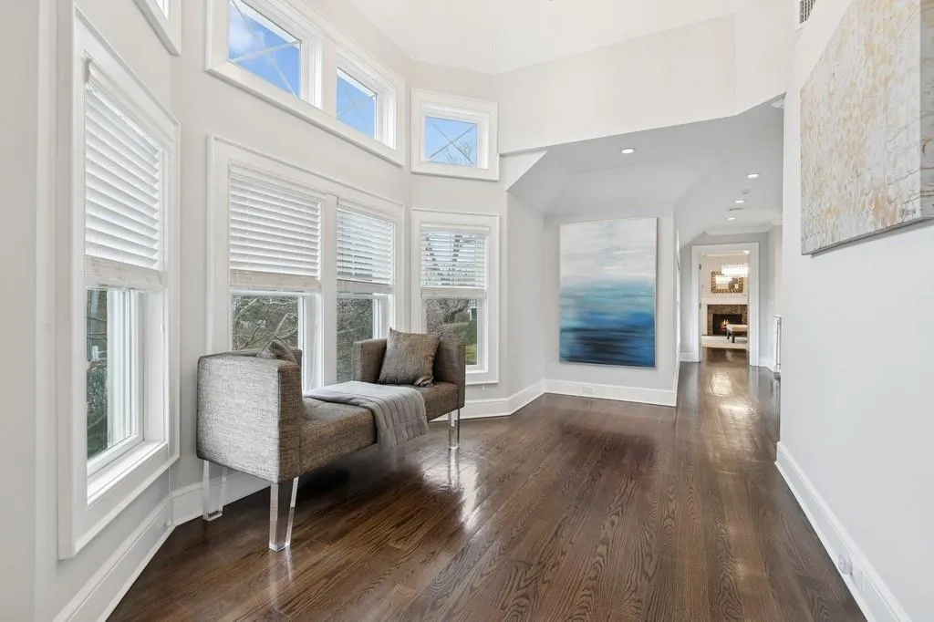 Sitting room featuring dark wood finished floors, a fireplace, baseboards, and a towering ceiling Sitting room featuring dark wood finished floors, a fireplace, baseboards, and a towering ceiling