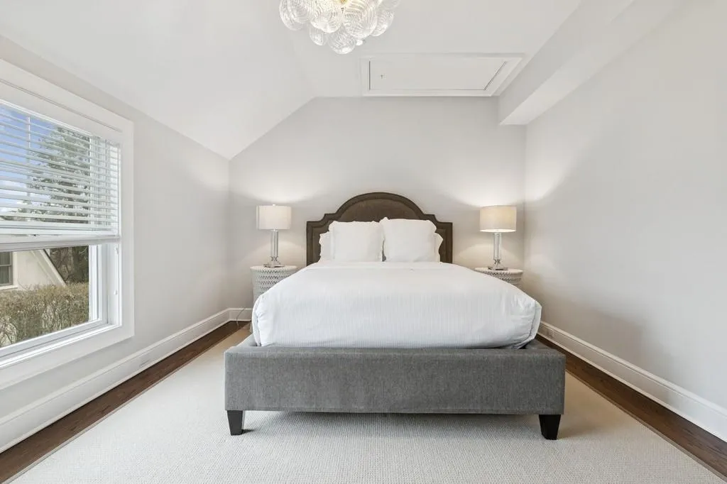 Bedroom featuring vaulted ceiling, wood finished floors, and baseboards Bedroom featuring vaulted ceiling, wood finished floors, and baseboards