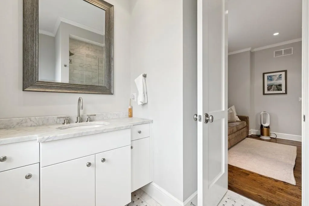 Bathroom featuring vanity, wood finished floors, baseboards, visible vents, and ornamental molding Bathroom featuring vanity, wood finished floors, baseboards, visible vents, and ornamental molding