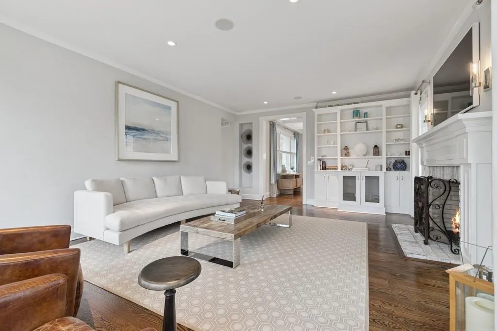Living room with recessed lighting, ornamental molding, a brick fireplace, and wood finished floors Living room with recessed lighting, ornamental molding, a brick fireplace, and wood finished floors