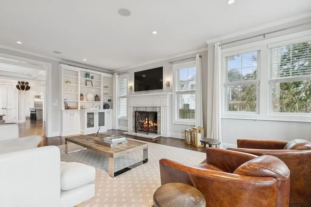Living area with recessed lighting, wood finished floors, a fireplace, and crown molding Living area with recessed lighting, wood finished floors, a fireplace, and crown molding