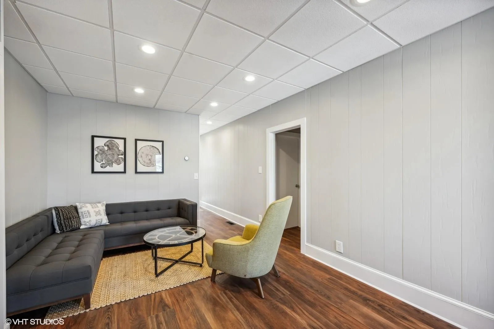 Living room with a drop ceiling, recessed lighting, baseboards, and wood finished floors Living room with a drop ceiling, recessed lighting, baseboards, and wood finished floors