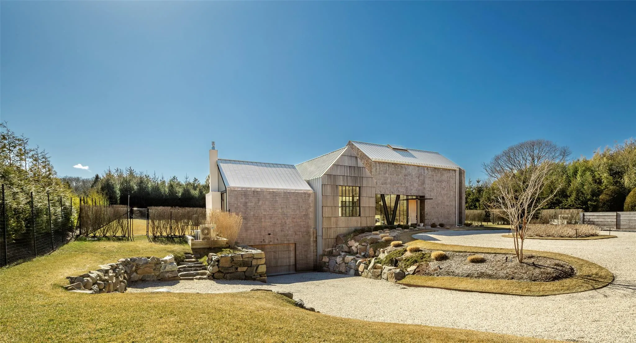 View of front facade featuring an outbuilding, gravel driveway, a front yard, and fence View of front facade featuring an outbuilding, gravel driveway, a front yard, and fence
