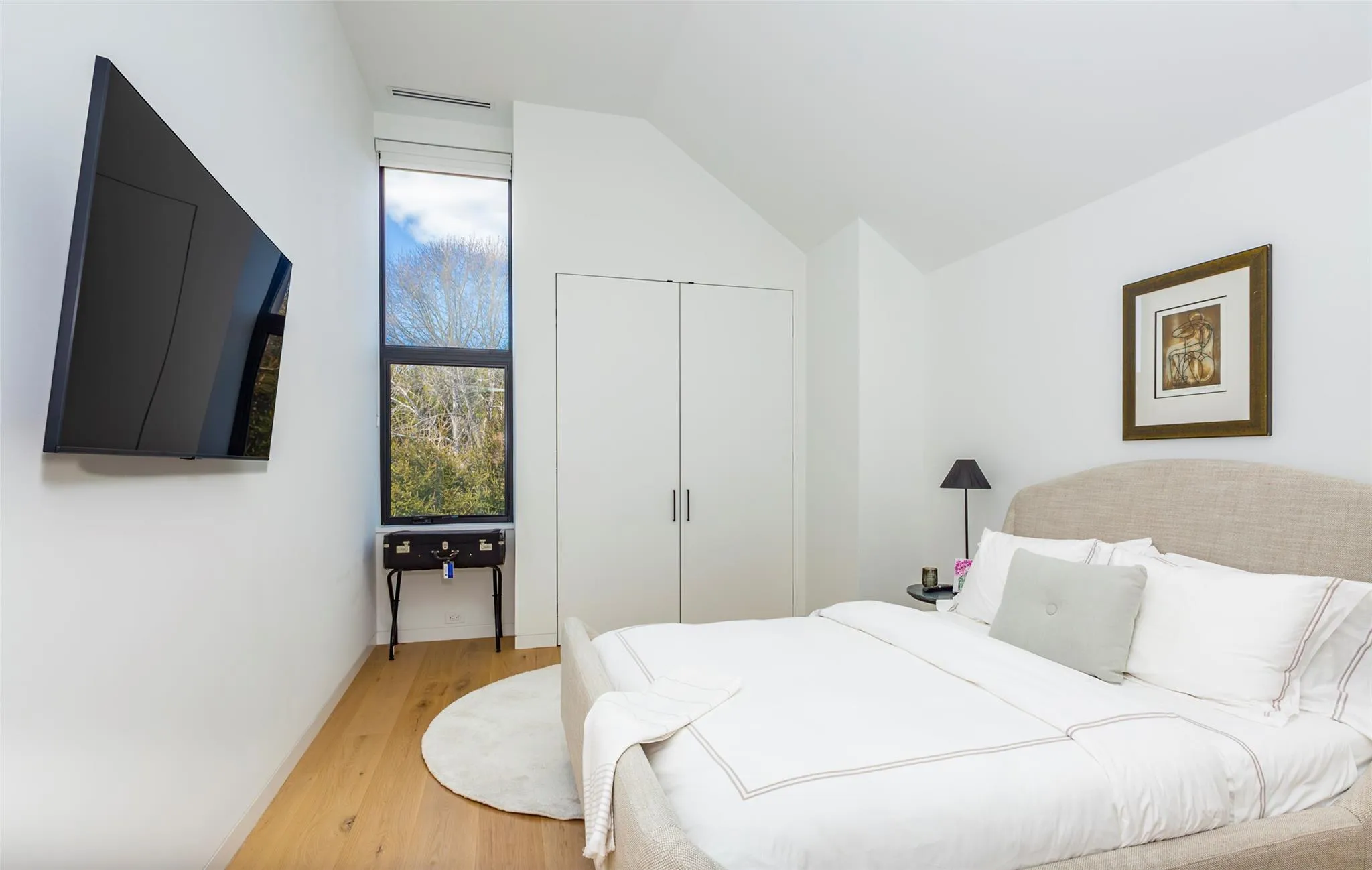 Bedroom with a closet, visible vents, light wood-style floors, and vaulted ceiling Bedroom with a closet, visible vents, light wood-style floors, and vaulted ceiling