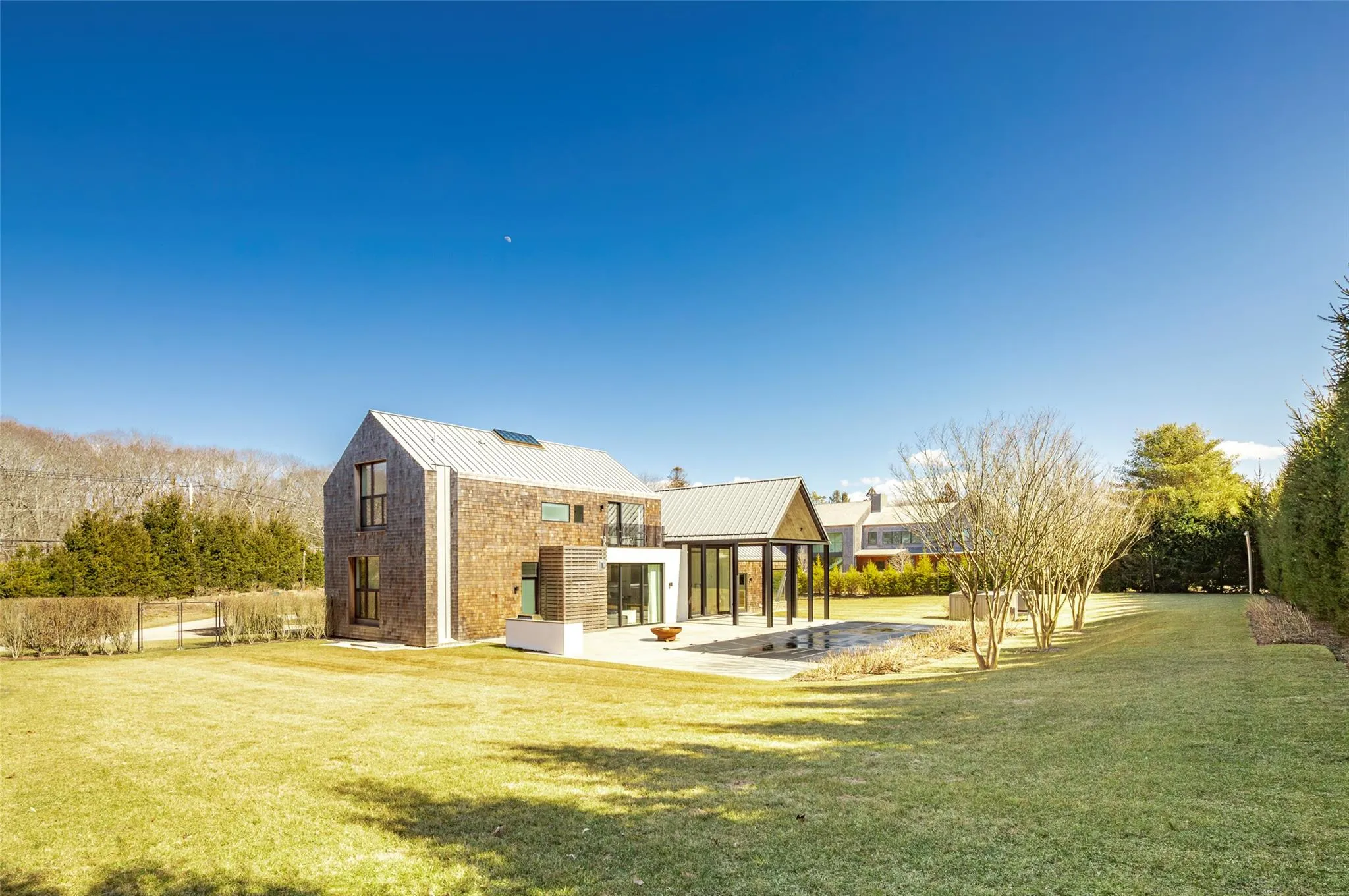 Rear view of house with metal roof, a lawn, a standing seam roof, and fence Rear view of house with metal roof, a lawn, a standing seam roof, and fence