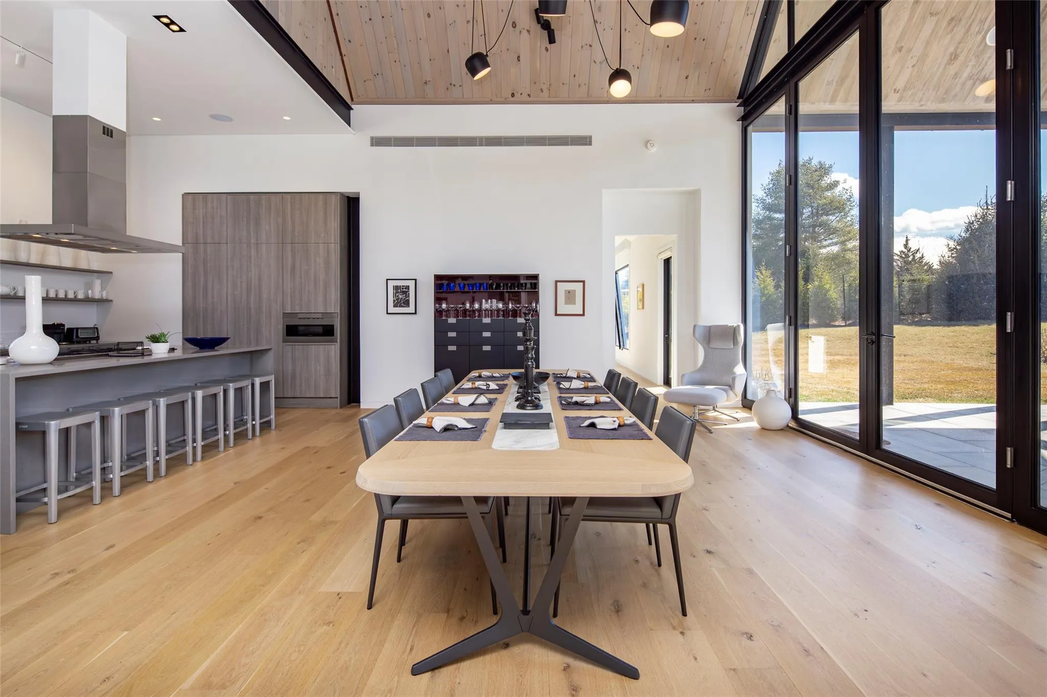 Dining area with visible vents, light wood-style flooring, wood ceiling, and expansive windows Dining area with visible vents, light wood-style flooring, wood ceiling, and expansive windows