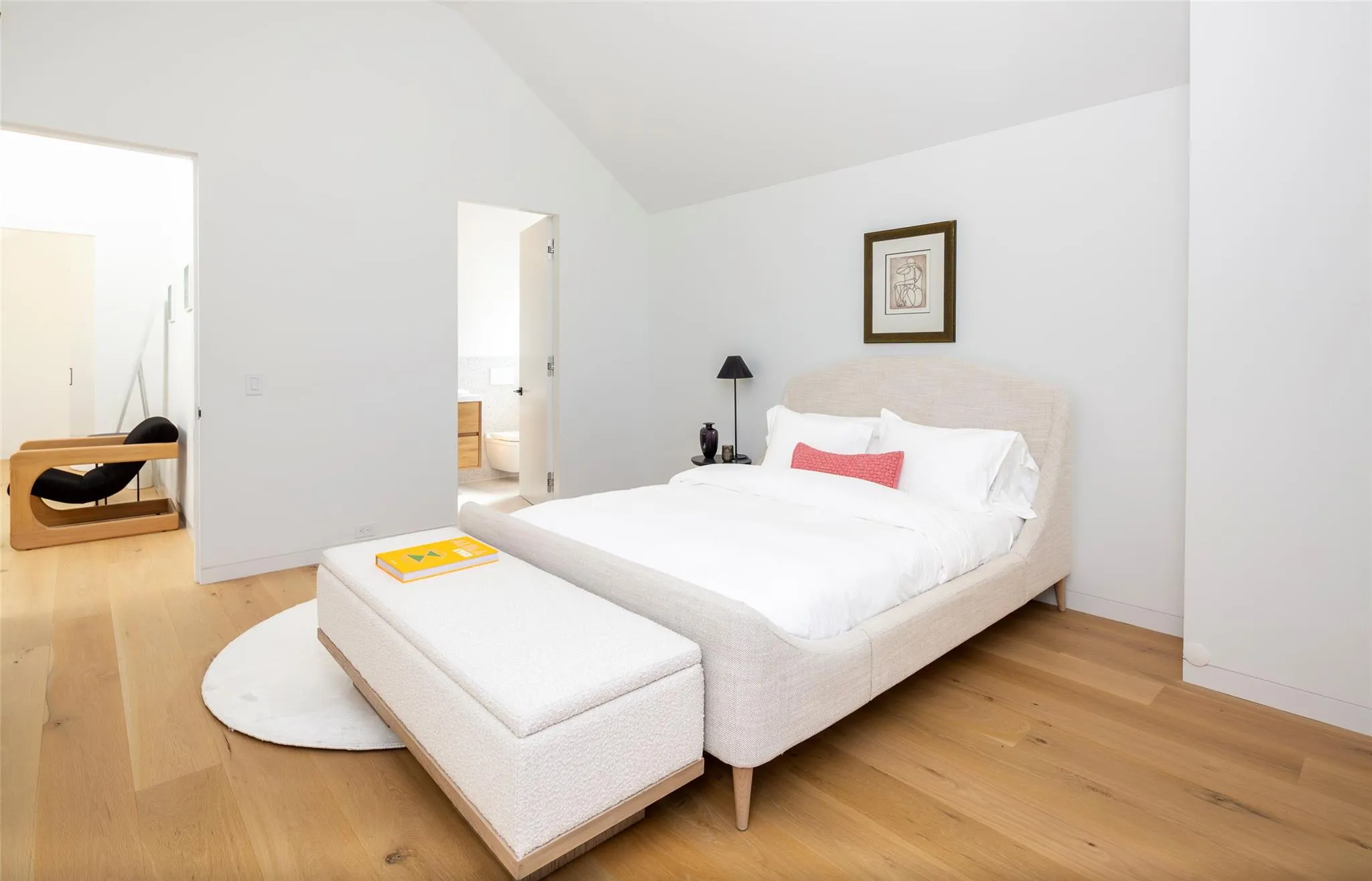 Bedroom featuring vaulted ceiling, baseboards, light wood-type flooring, and ensuite bathroom Bedroom featuring vaulted ceiling, baseboards, light wood-type flooring, and ensuite bathroom