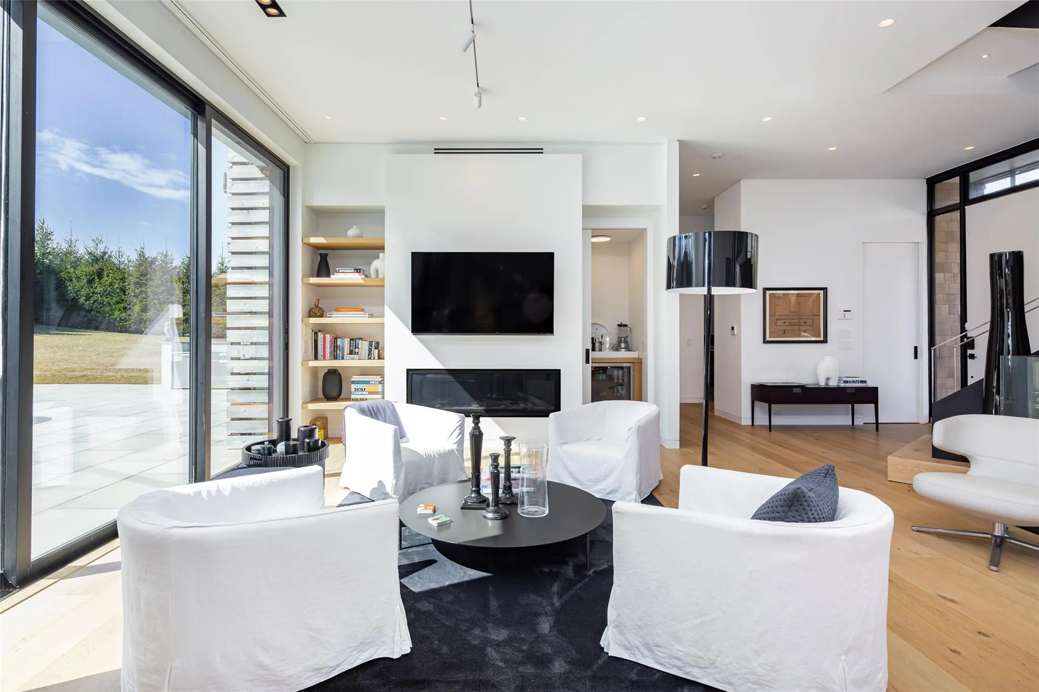 Living room featuring a glass covered fireplace, recessed lighting, and light wood-type flooring Living room featuring a glass covered fireplace, recessed lighting, and light wood-type flooring