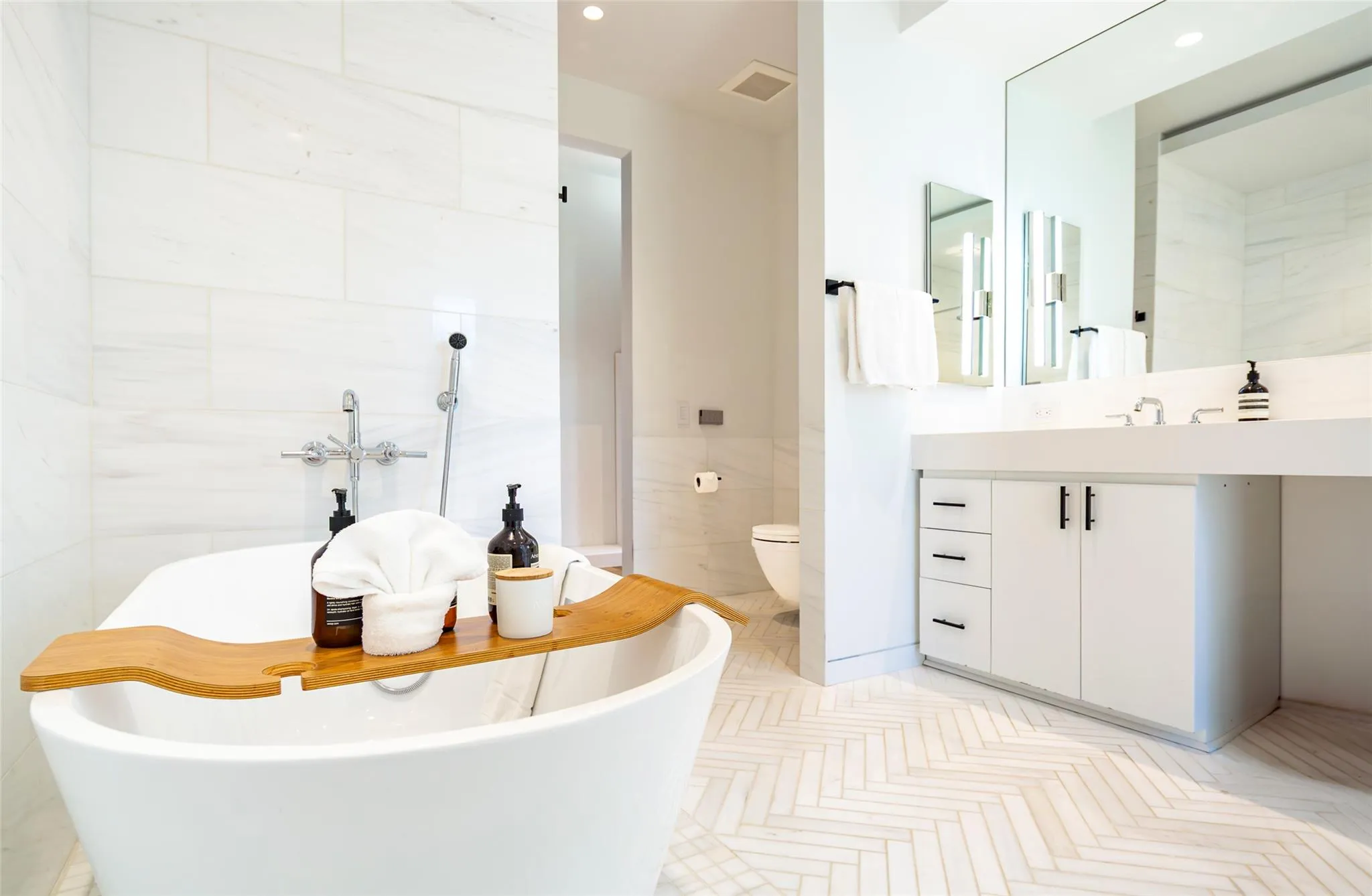 Bathroom featuring vanity, visible vents, a freestanding tub, tile walls, and toilet Bathroom featuring vanity, visible vents, a freestanding tub, tile walls, and toilet