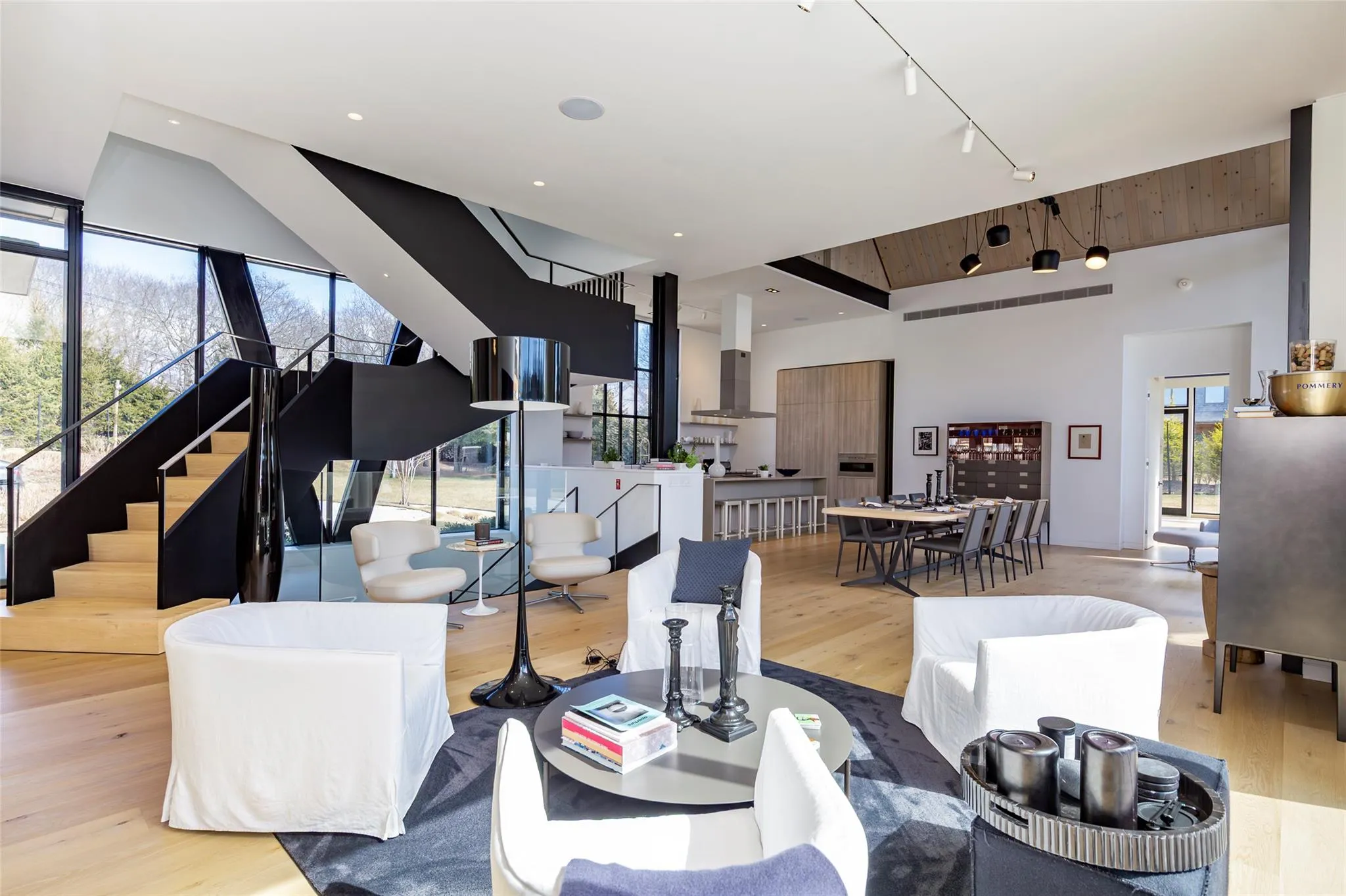 Living room featuring stairway, wood finished floors, recessed lighting, track lighting, and a towering ceiling Living room featuring stairway, wood finished floors, recessed lighting, track lighting, and a towering ceiling