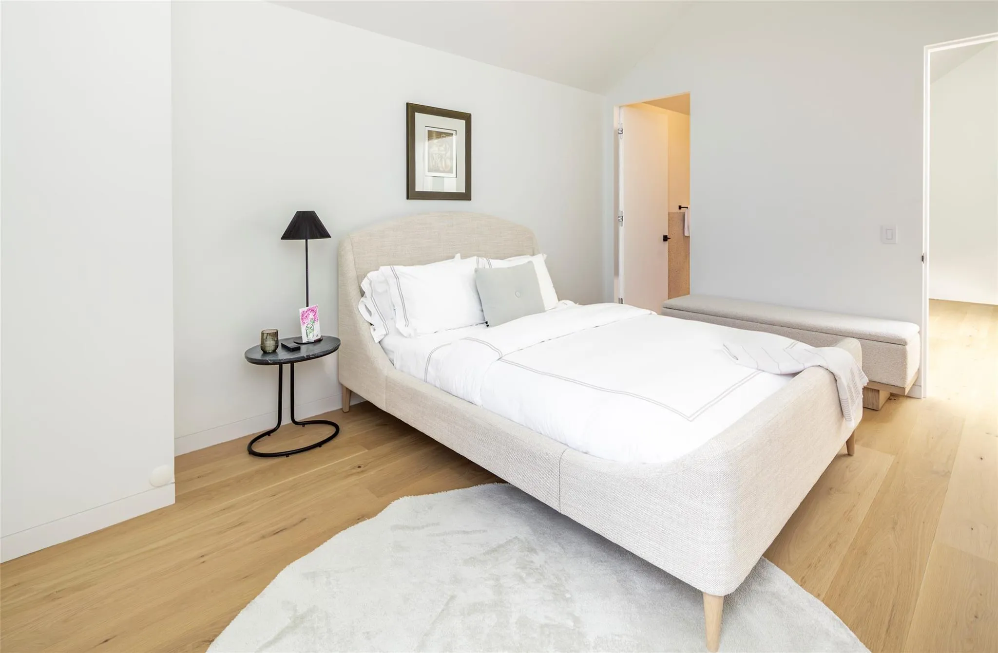 Bedroom with vaulted ceiling, light wood-style flooring, and baseboards Bedroom with vaulted ceiling, light wood-style flooring, and baseboards
