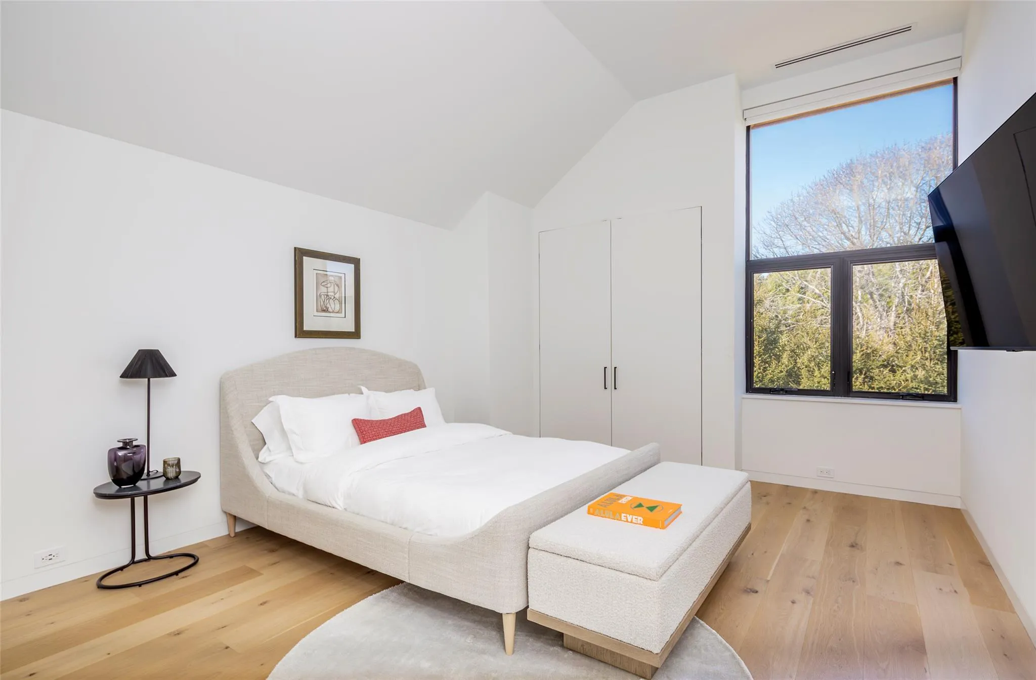 Bedroom with vaulted ceiling, baseboards, visible vents, and light wood-type flooring Bedroom with vaulted ceiling, baseboards, visible vents, and light wood-type flooring