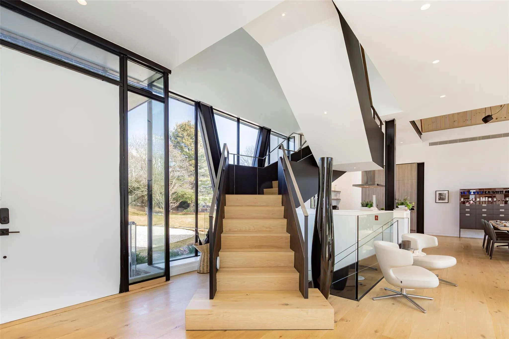 Stairway featuring washer and dryer, a wall of windows, recessed lighting, and wood finished floors Stairway featuring washer and dryer, a wall of windows, recessed lighting, and wood finished floors