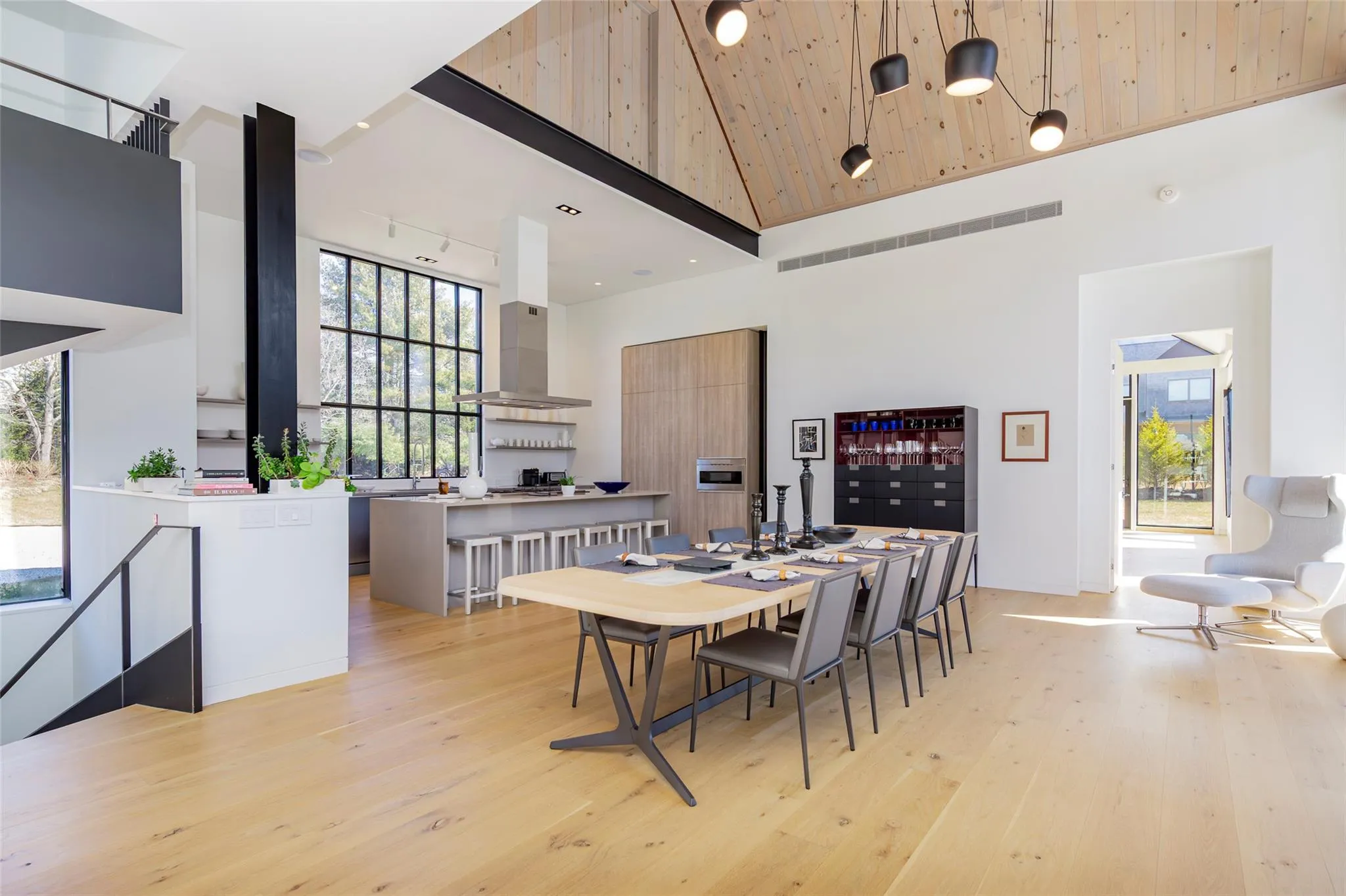 Dining space featuring rail lighting, light wood-style floors, a healthy amount of sunlight, and high vaulted ceiling Dining space featuring rail lighting, light wood-style floors, a healthy amount of sunlight, and high vaulted ceiling