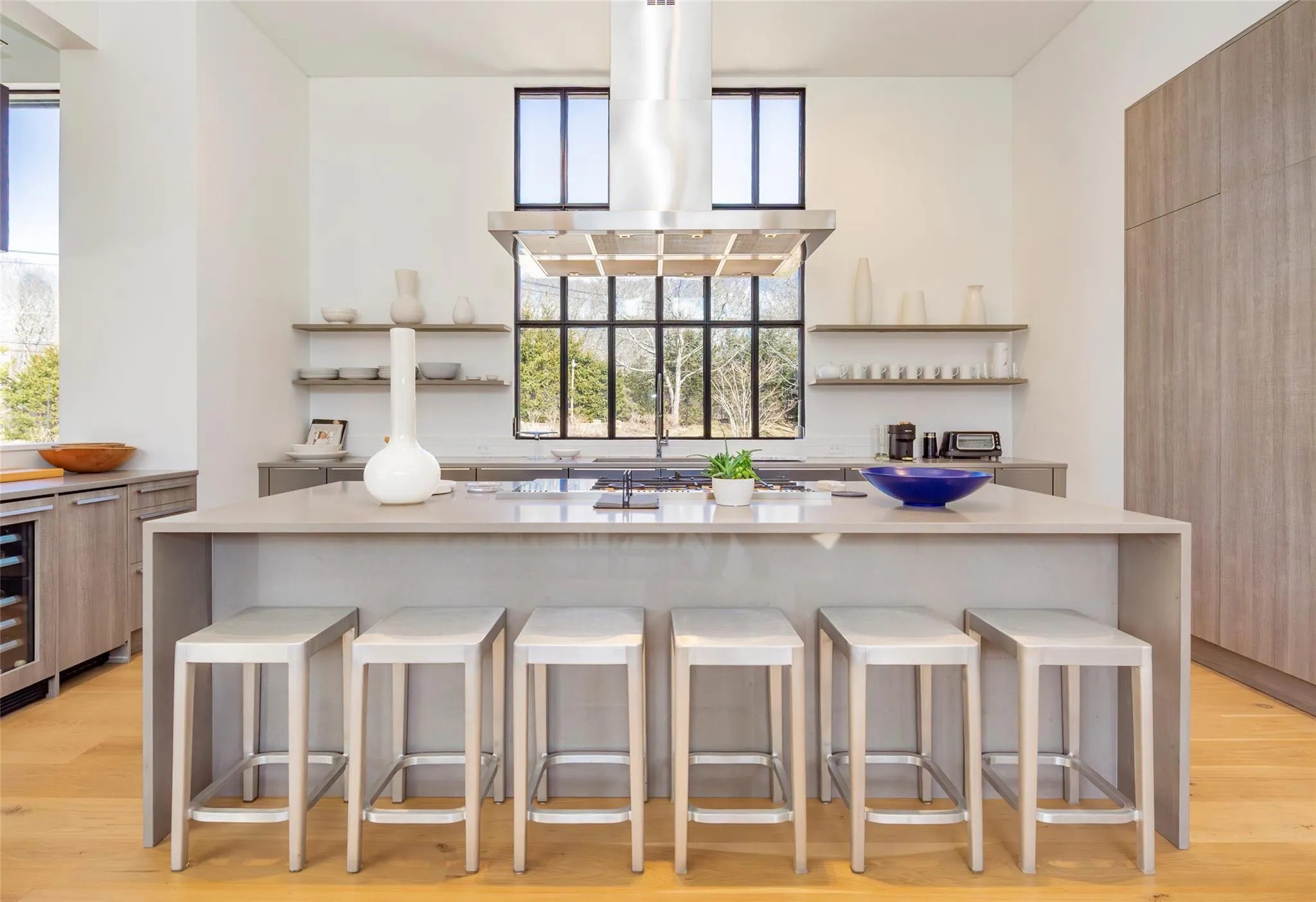Bar with island exhaust hood, light wood-type flooring, and beverage cooler Bar with island exhaust hood, light wood-type flooring, and beverage cooler