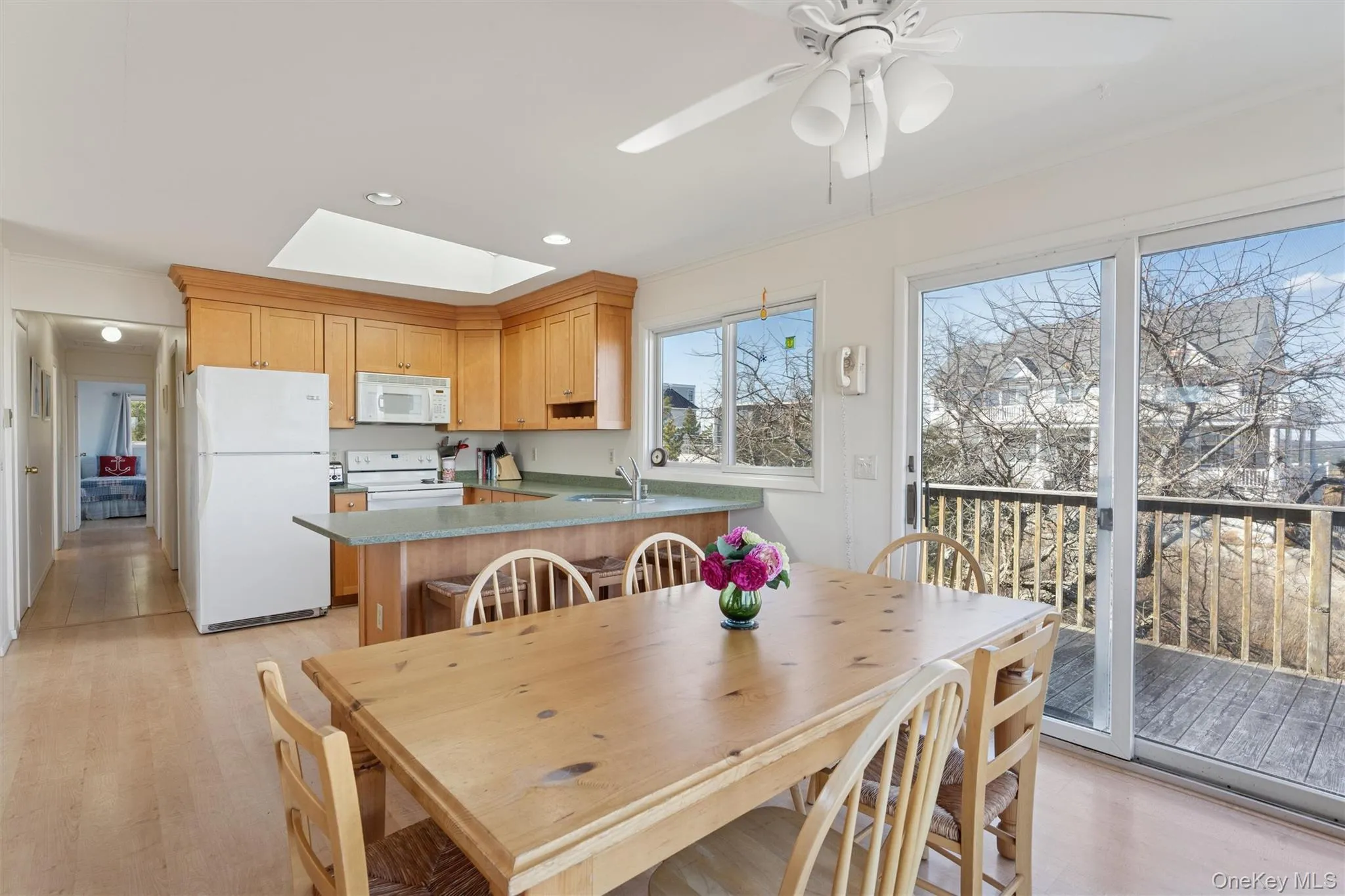Dining space featuring light wood-type flooring, a ceiling fan, recessed lighting, a skylight, and crown molding Dining space featuring light wood-type flooring, a ceiling fan, recessed lighting, a skylight, and crown molding