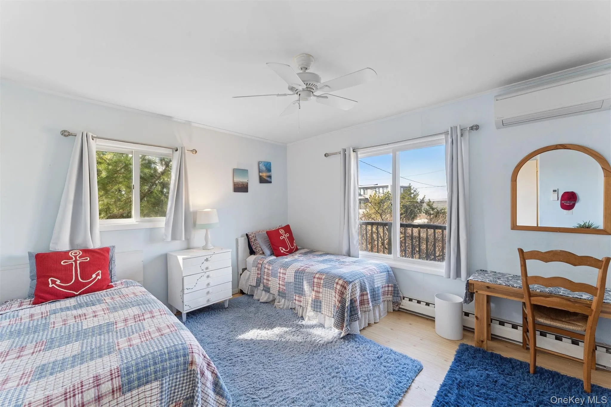 Bedroom with baseboard heating, a wall mounted air conditioner, a ceiling fan, and wood finished floors Bedroom with baseboard heating, a wall mounted air conditioner, a ceiling fan, and wood finished floors