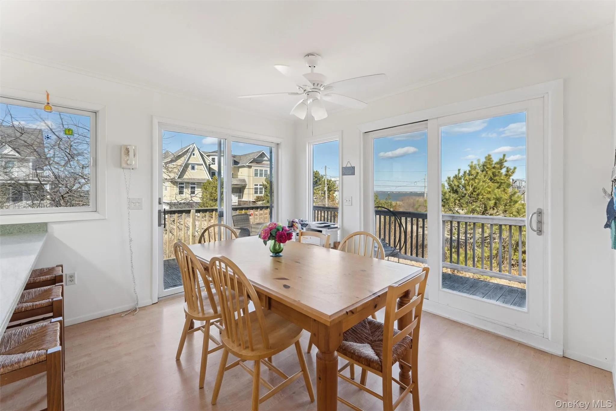 Dining area with light wood finished floors, a ceiling fan, and baseboards Dining area with light wood finished floors, a ceiling fan, and baseboards