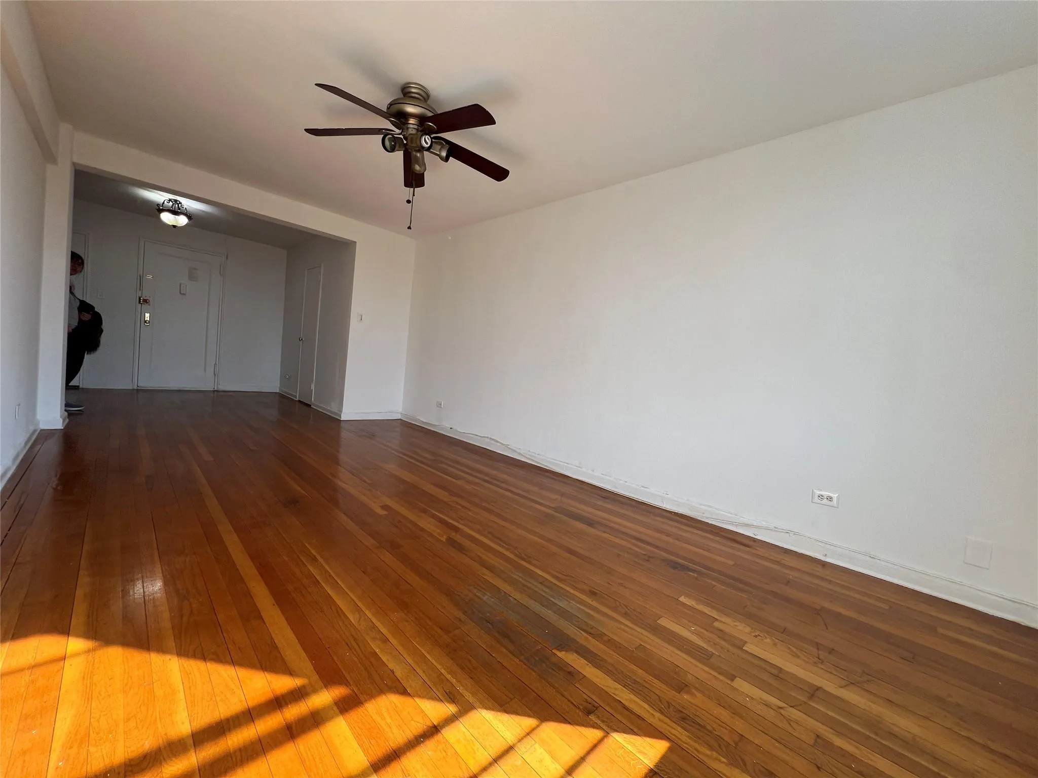 Empty room featuring ceiling fan, baseboards, and hardwood / wood-style flooring Empty room featuring ceiling fan, baseboards, and hardwood / wood-style flooring