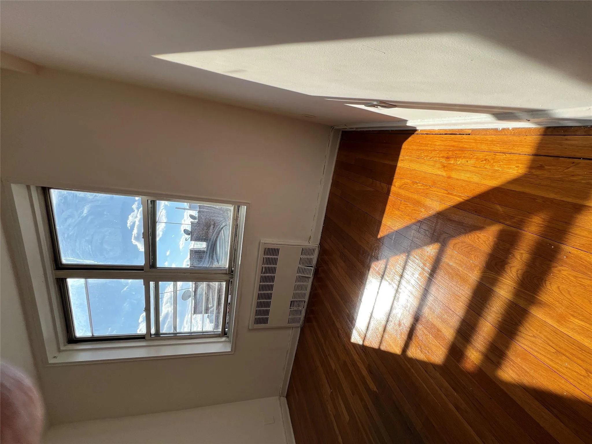 Unfurnished room featuring baseboards, radiator heating unit, and hardwood / wood-style flooring Unfurnished room featuring baseboards, radiator heating unit, and hardwood / wood-style flooring