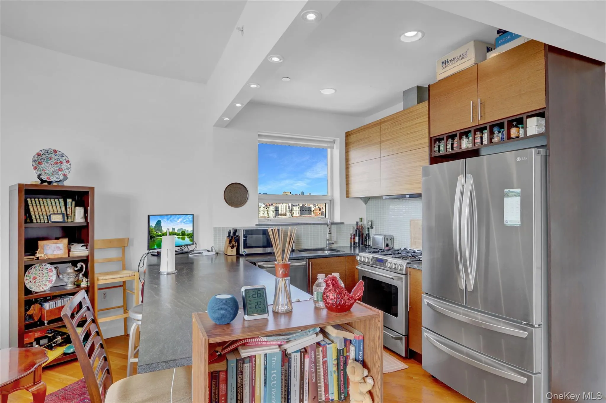Kitchen featuring light wood-style flooring, a sink, backsplash, stainless steel appliances, and extractor fan Kitchen featuring light wood-style flooring, a sink, backsplash, stainless steel appliances, and extractor fan
