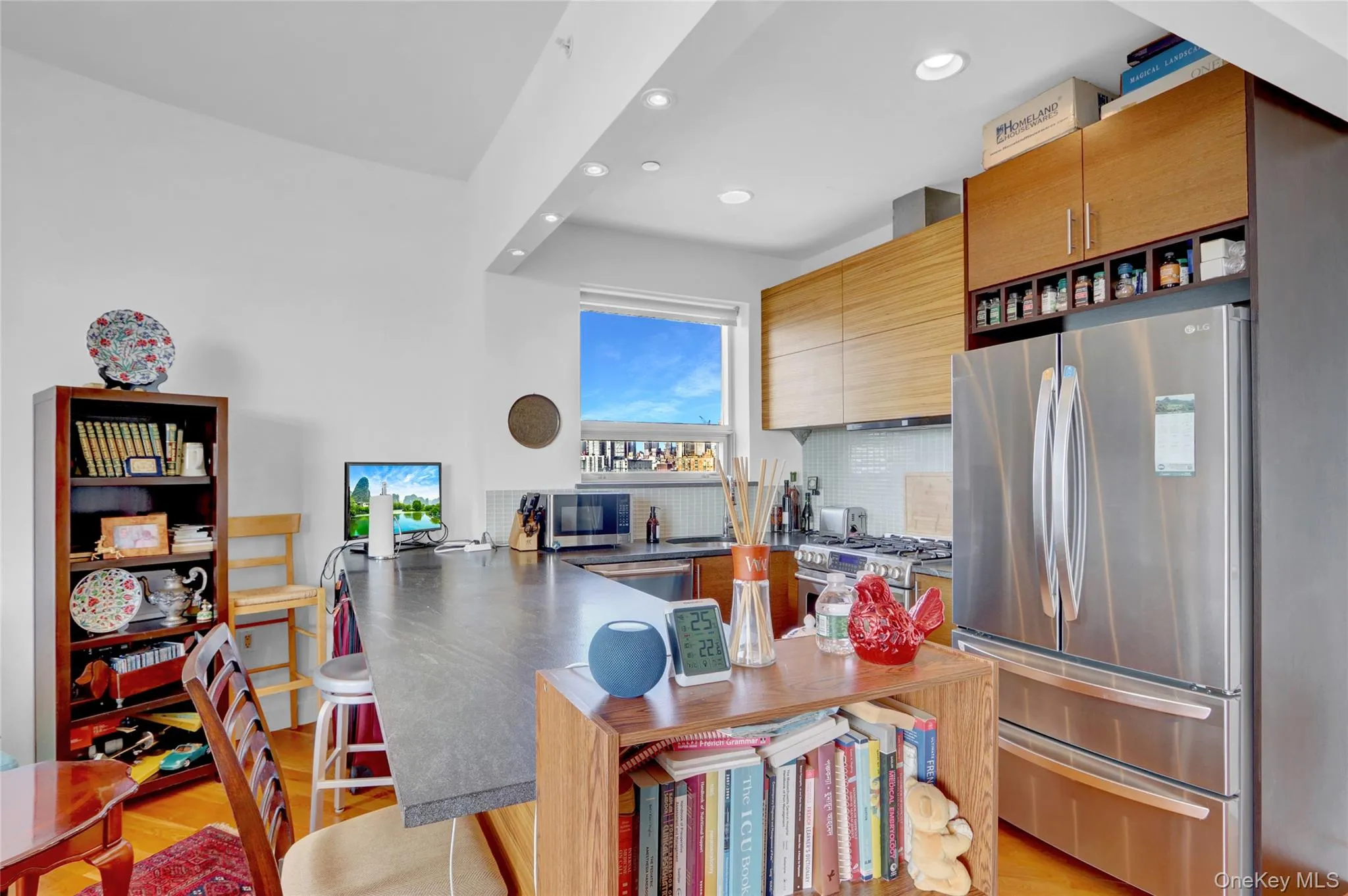Kitchen featuring a peninsula, recessed lighting, stainless steel appliances, decorative backsplash, and wall chimney exhaust hood Kitchen featuring a peninsula, recessed lighting, stainless steel appliances, decorative backsplash, and wall chimney exhaust hood