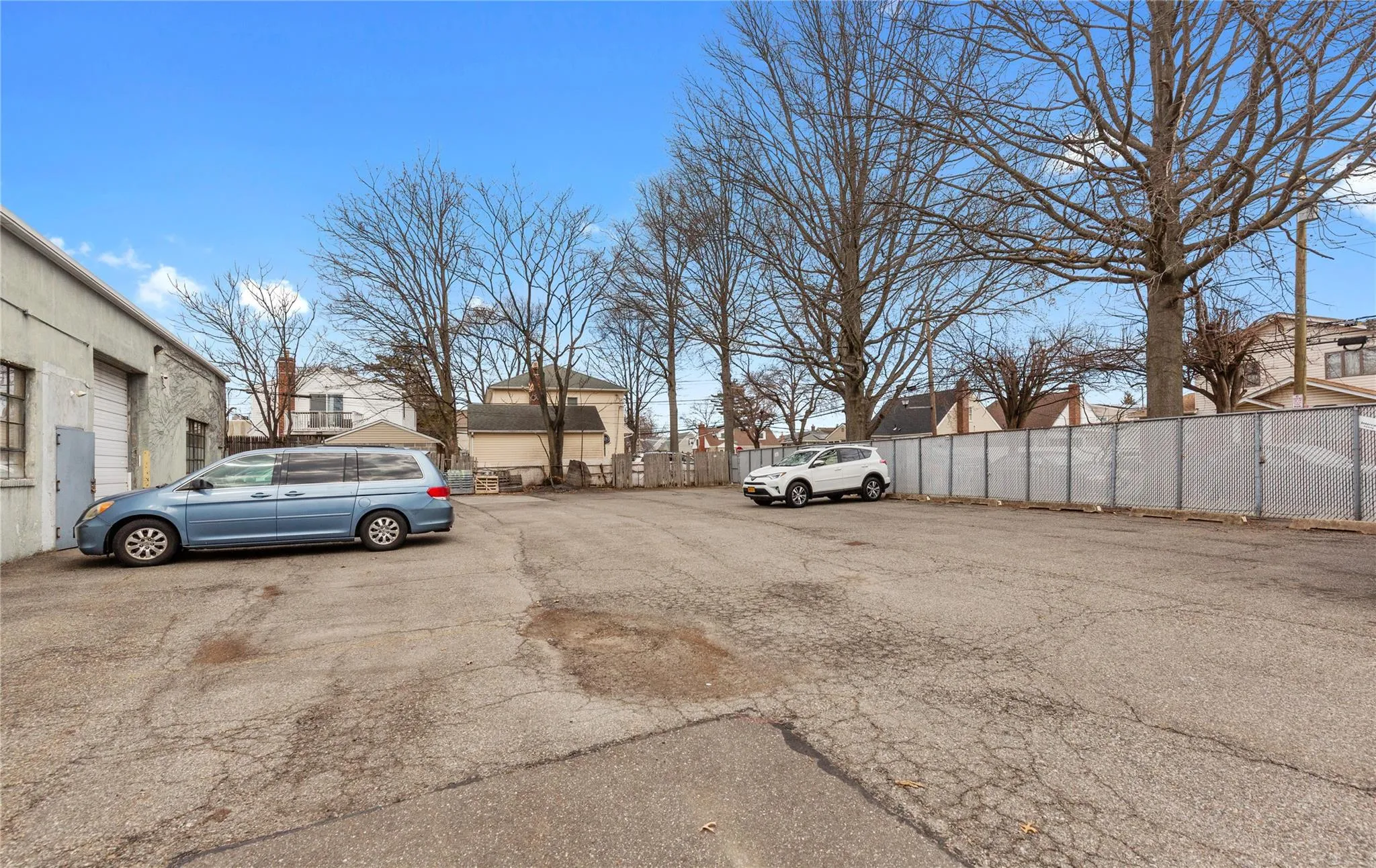 Uncovered parking lot featuring fence Uncovered parking lot featuring fence