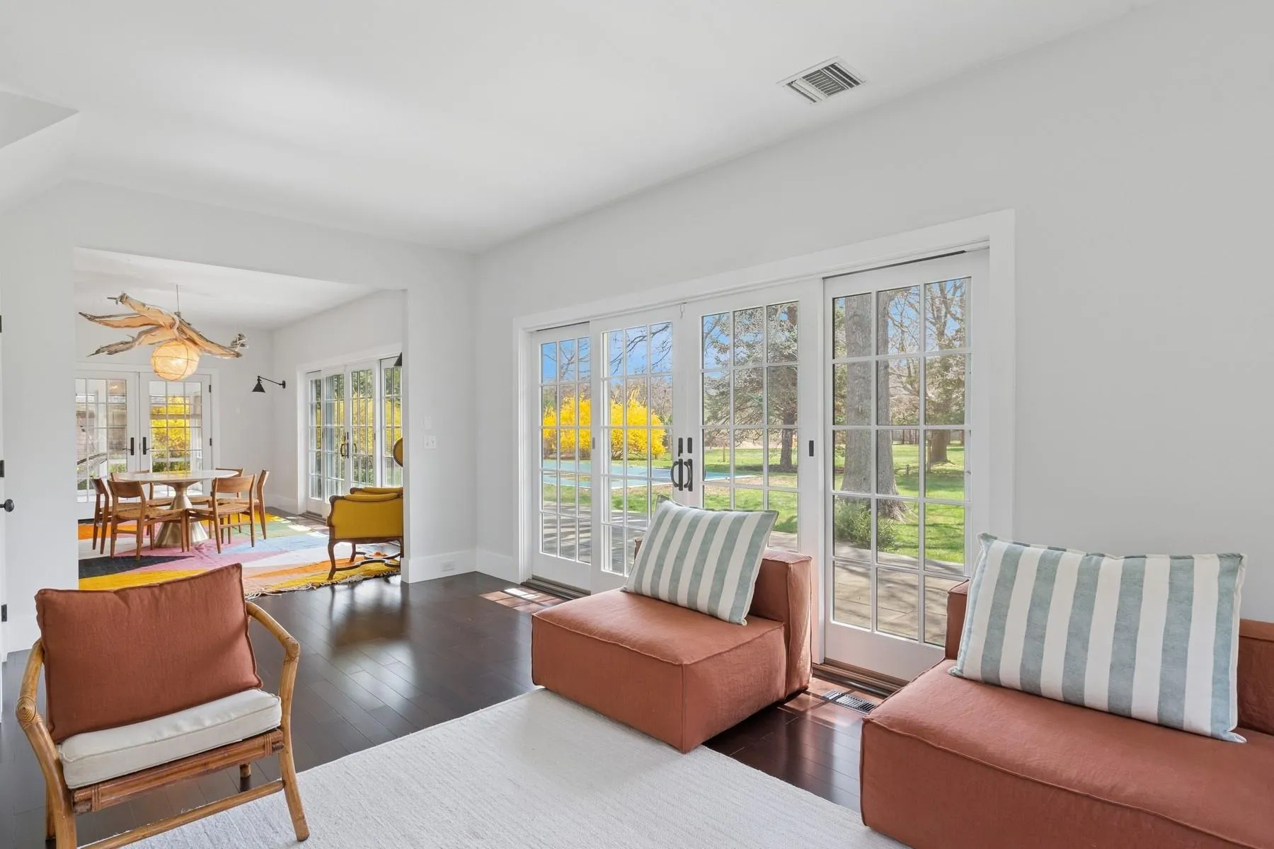 Living area featuring hardwood / wood-style floors, visible vents, baseboards, and an inviting chandelier Living area featuring hardwood / wood-style floors, visible vents, baseboards, and an inviting chandelier