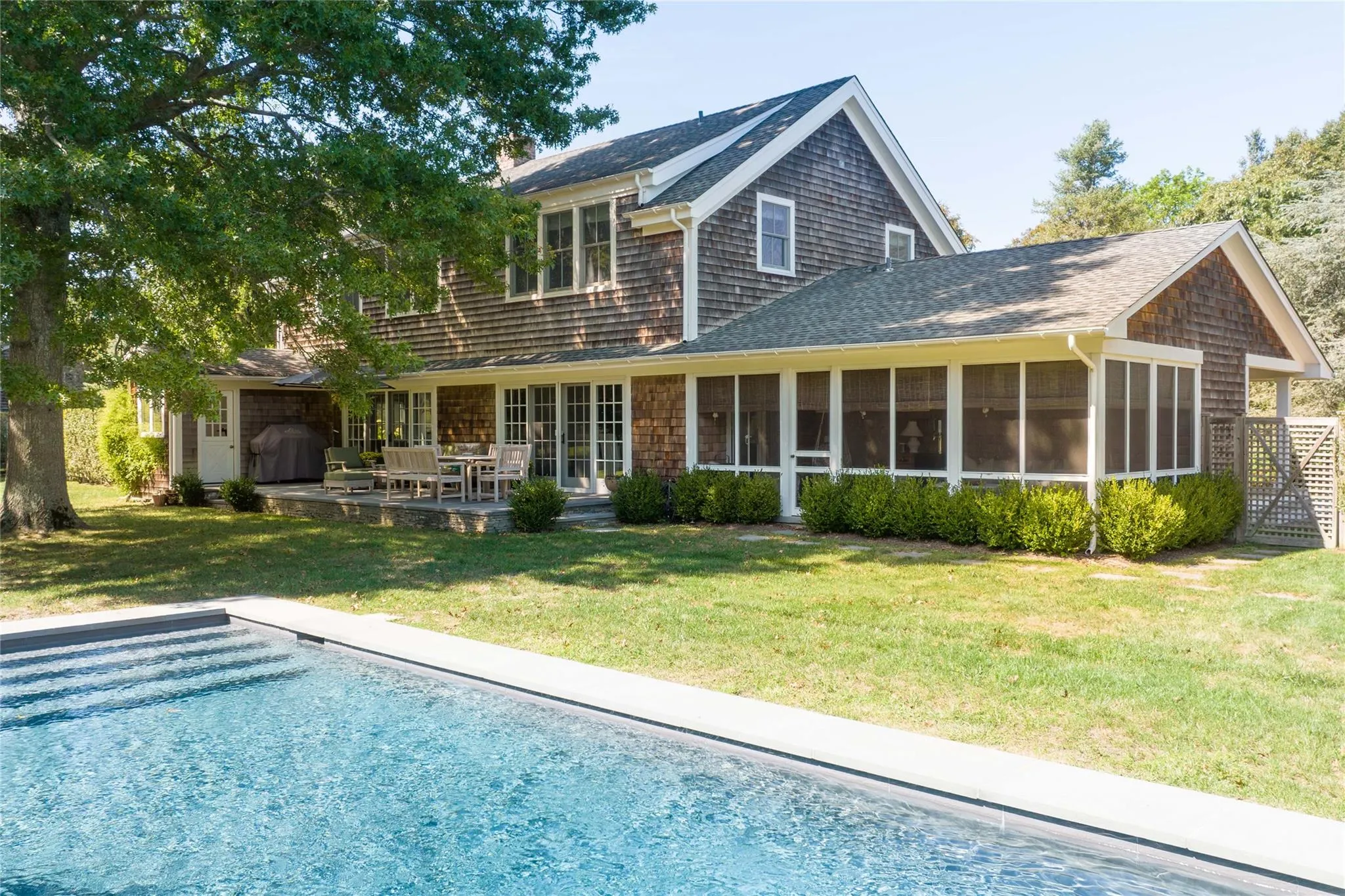 Back of house featuring a patio area, a yard, a chimney, and a sunroom Back of house featuring a patio area, a yard, a chimney, and a sunroom