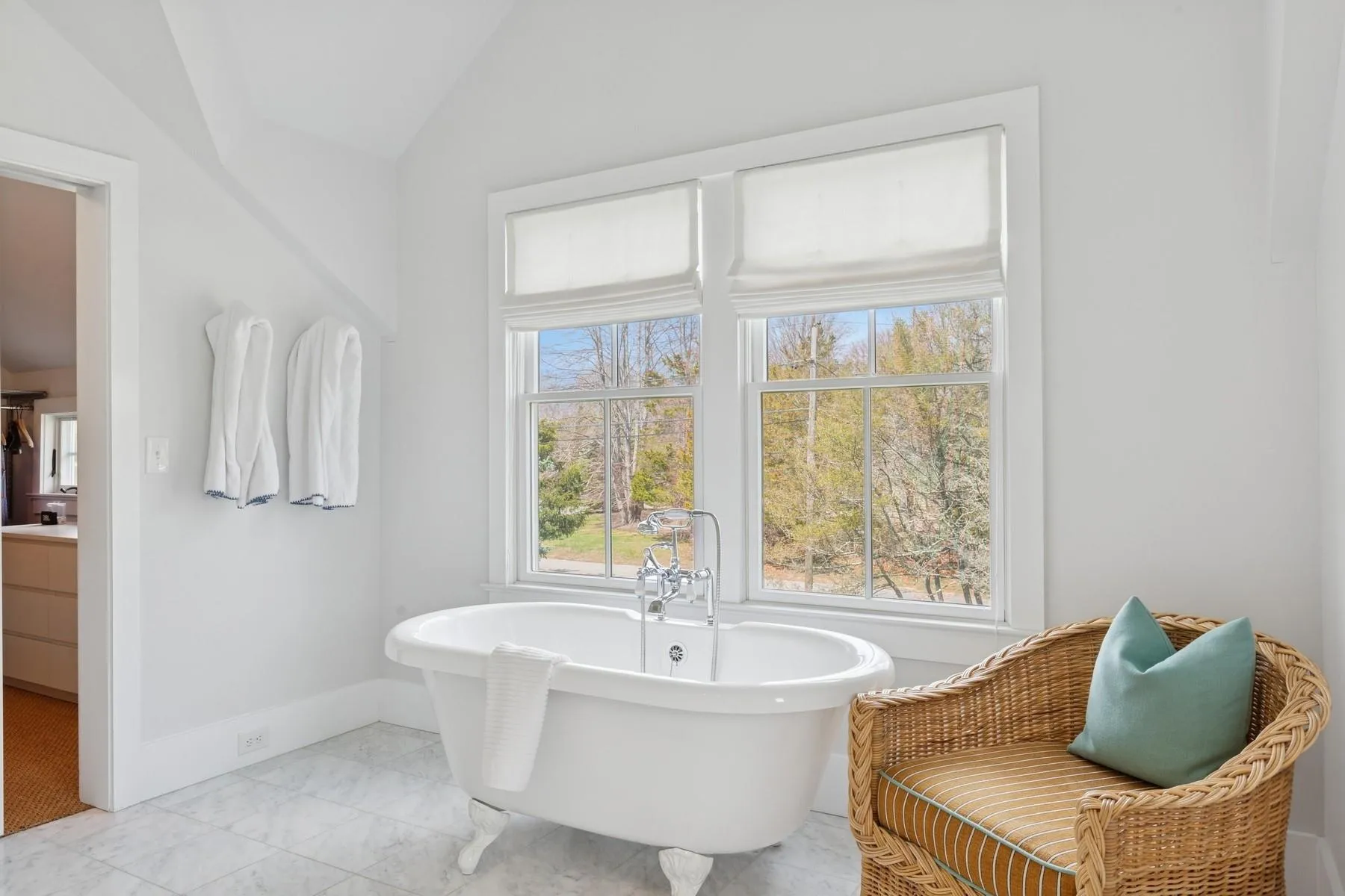 Full bath featuring a soaking tub, vaulted ceiling, baseboards, marble finish floor, and vanity Full bath featuring a soaking tub, vaulted ceiling, baseboards, marble finish floor, and vanity