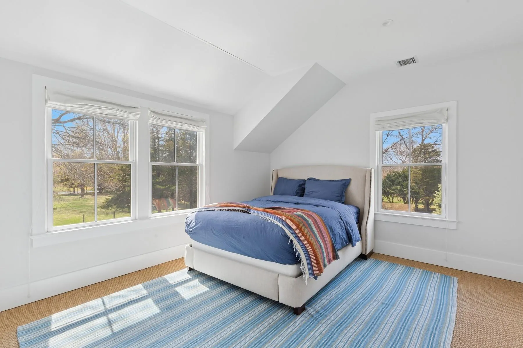 Carpeted bedroom featuring vaulted ceiling and visible vents Carpeted bedroom featuring vaulted ceiling and visible vents