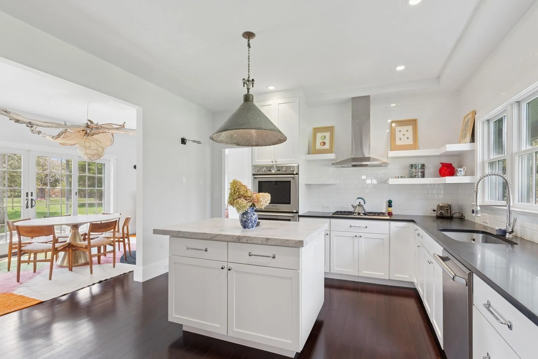 Kitchen featuring stainless steel appliances, open shelves, a sink, wall chimney exhaust hood, and decorative backsplash Kitchen featuring stainless steel appliances, open shelves, a sink, wall chimney exhaust hood, and decorative backsplash