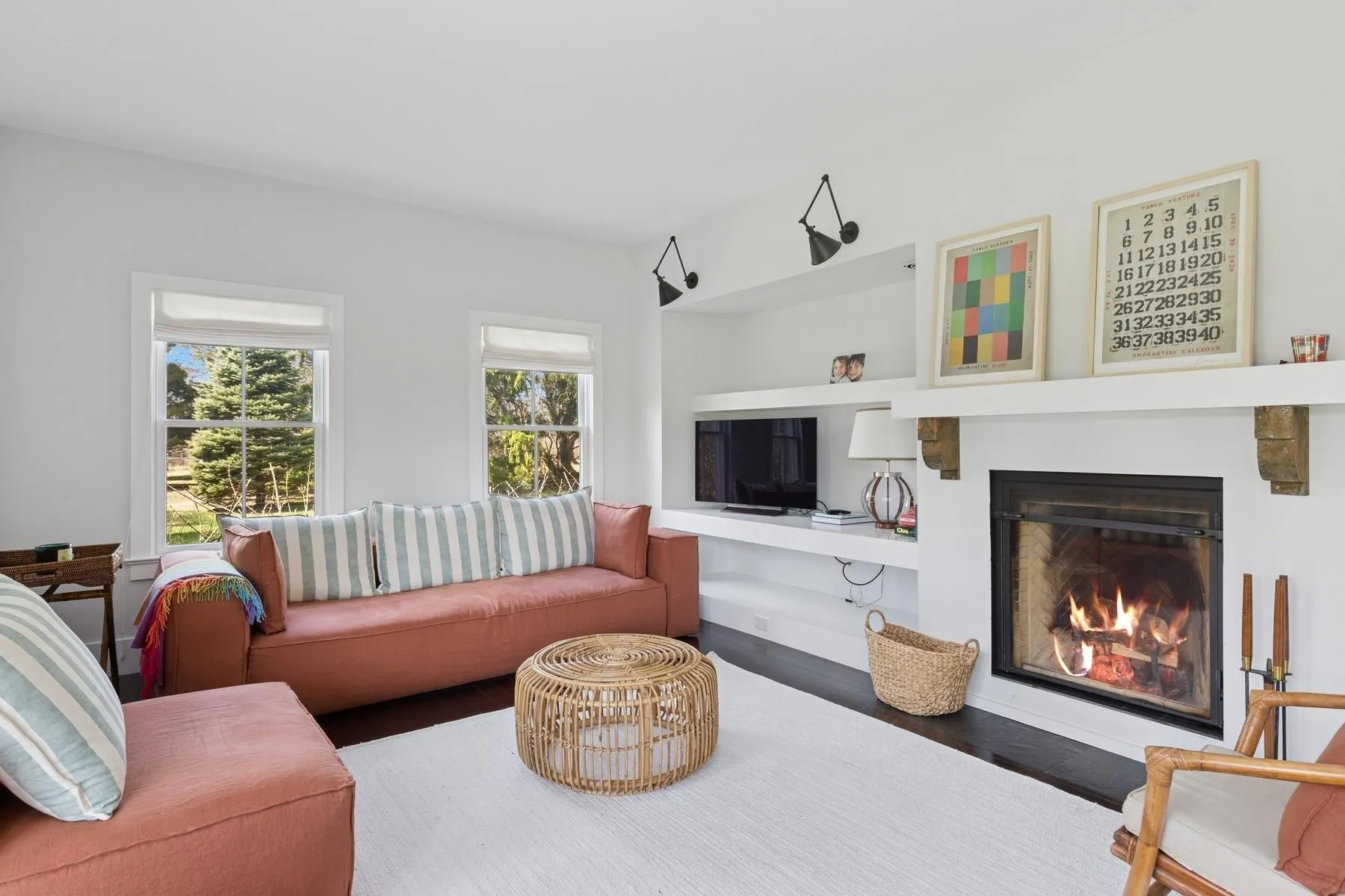 Living room featuring wood finished floors and a lit fireplace Living room featuring wood finished floors and a lit fireplace