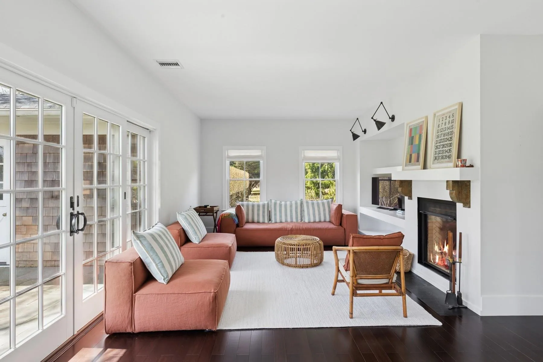 Living area with a glass covered fireplace, visible vents, dark wood-style floors, and french doors Living area with a glass covered fireplace, visible vents, dark wood-style floors, and french doors
