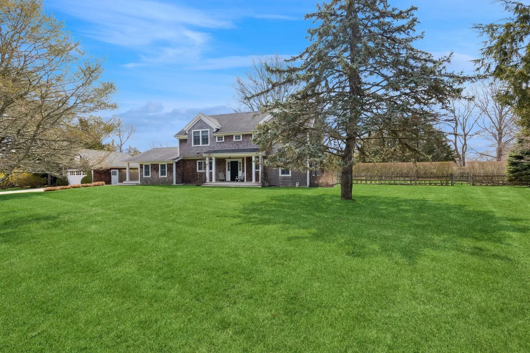 Back of property with a lawn, a porch, and fence Back of property with a lawn, a porch, and fence