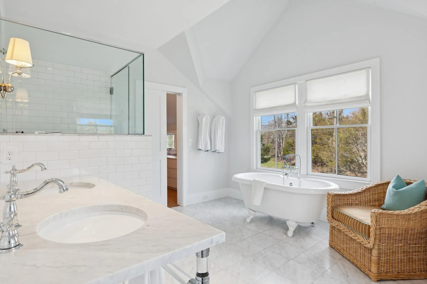 Bathroom featuring a tile shower, lofted ceiling, double vanity, a sink, and a freestanding tub Bathroom featuring a tile shower, lofted ceiling, double vanity, a sink, and a freestanding tub