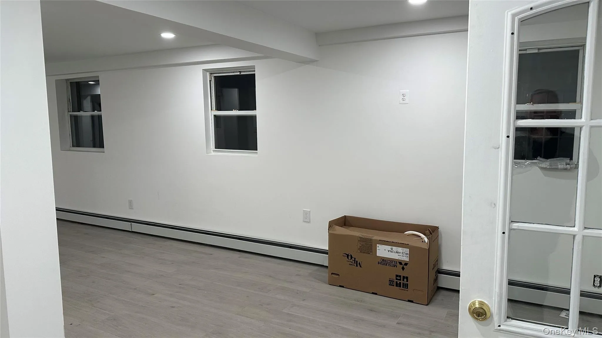 Finished below grade area with a baseboard radiator, recessed lighting, and light wood-type flooring Finished below grade area with a baseboard radiator, recessed lighting, and light wood-type flooring