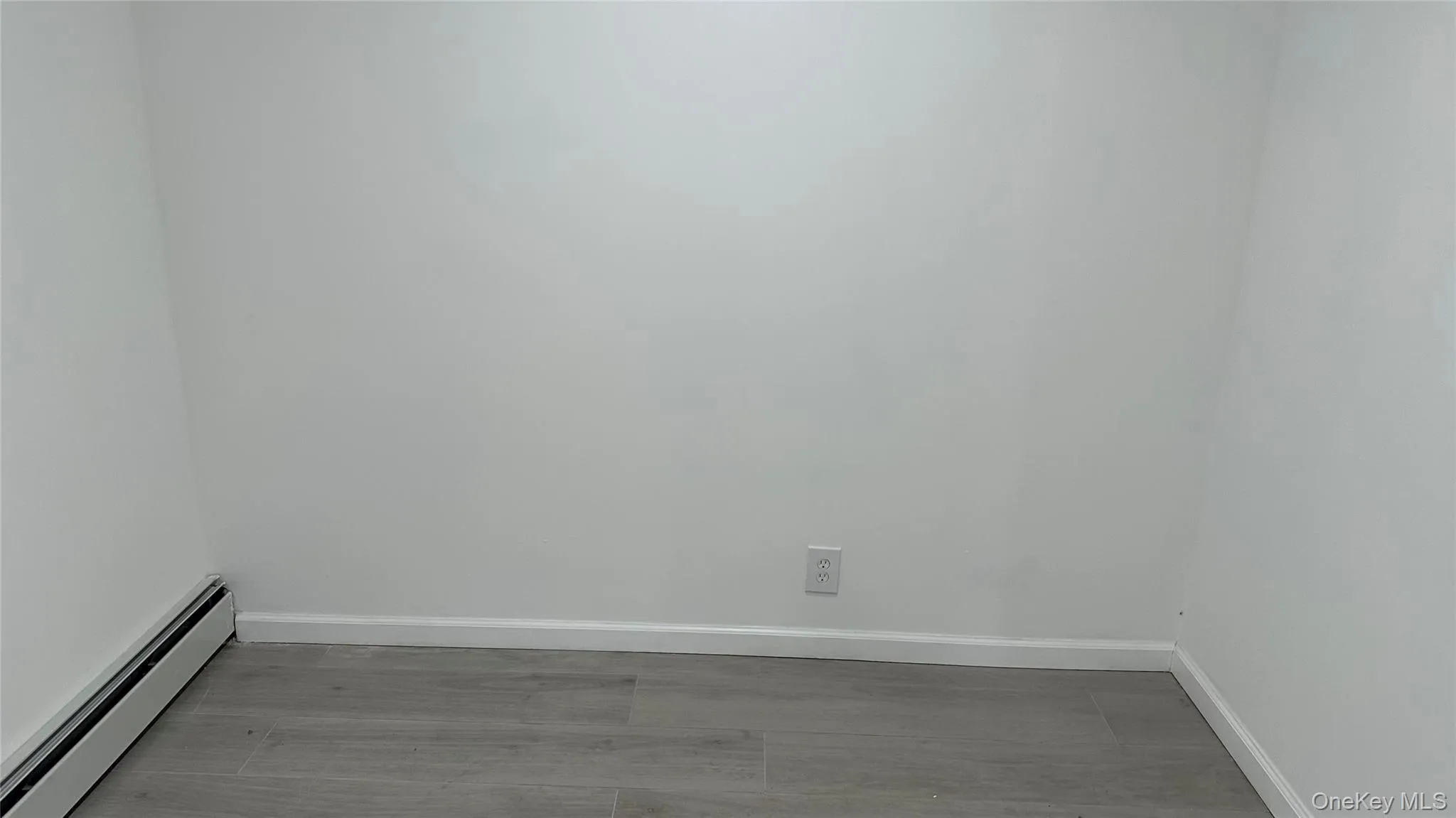 Empty room featuring a baseboard heating unit and baseboards Empty room featuring a baseboard heating unit and baseboards