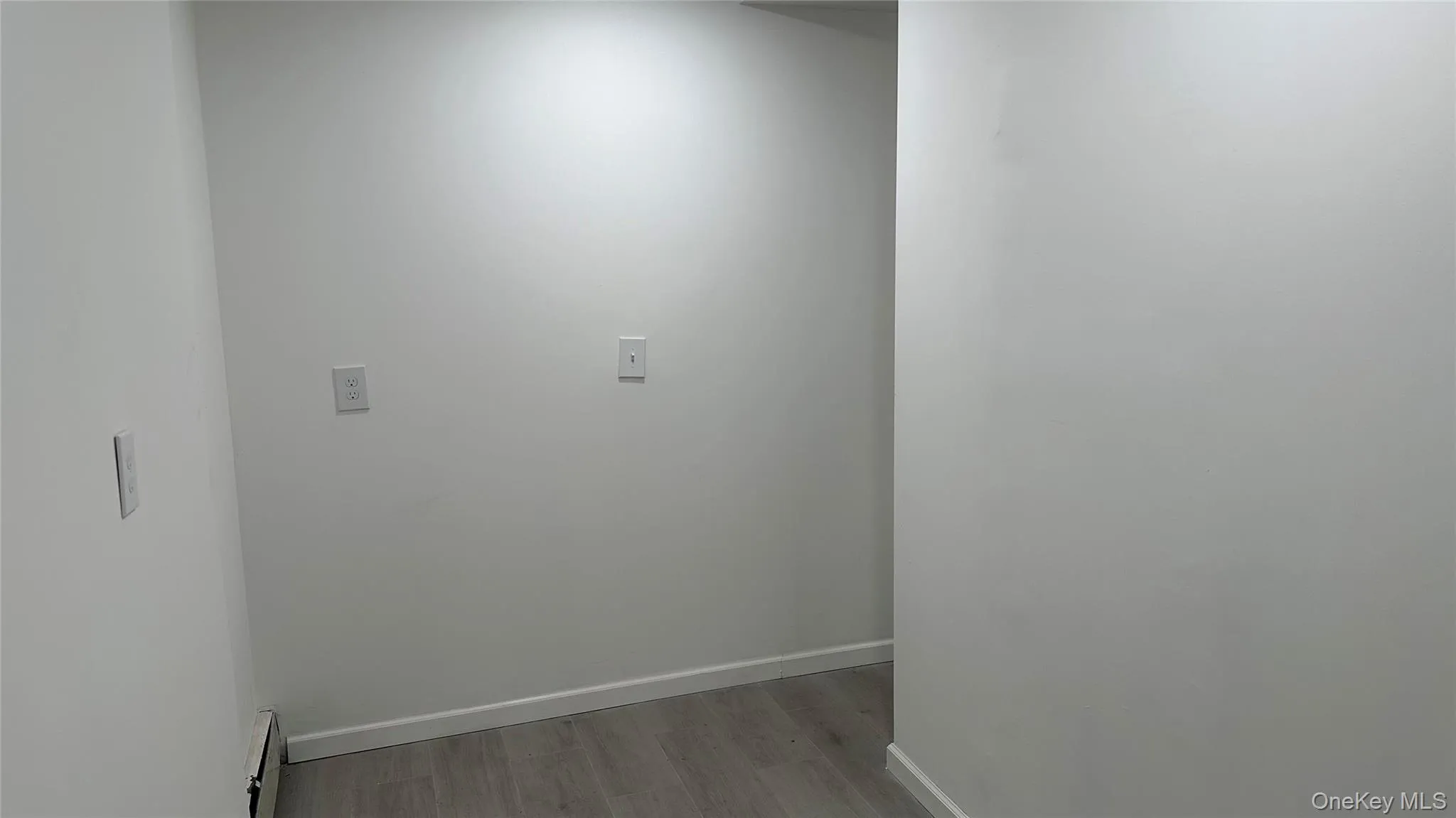 Washroom with light wood-style floors and a baseboard radiator Washroom with light wood-style floors and a baseboard radiator