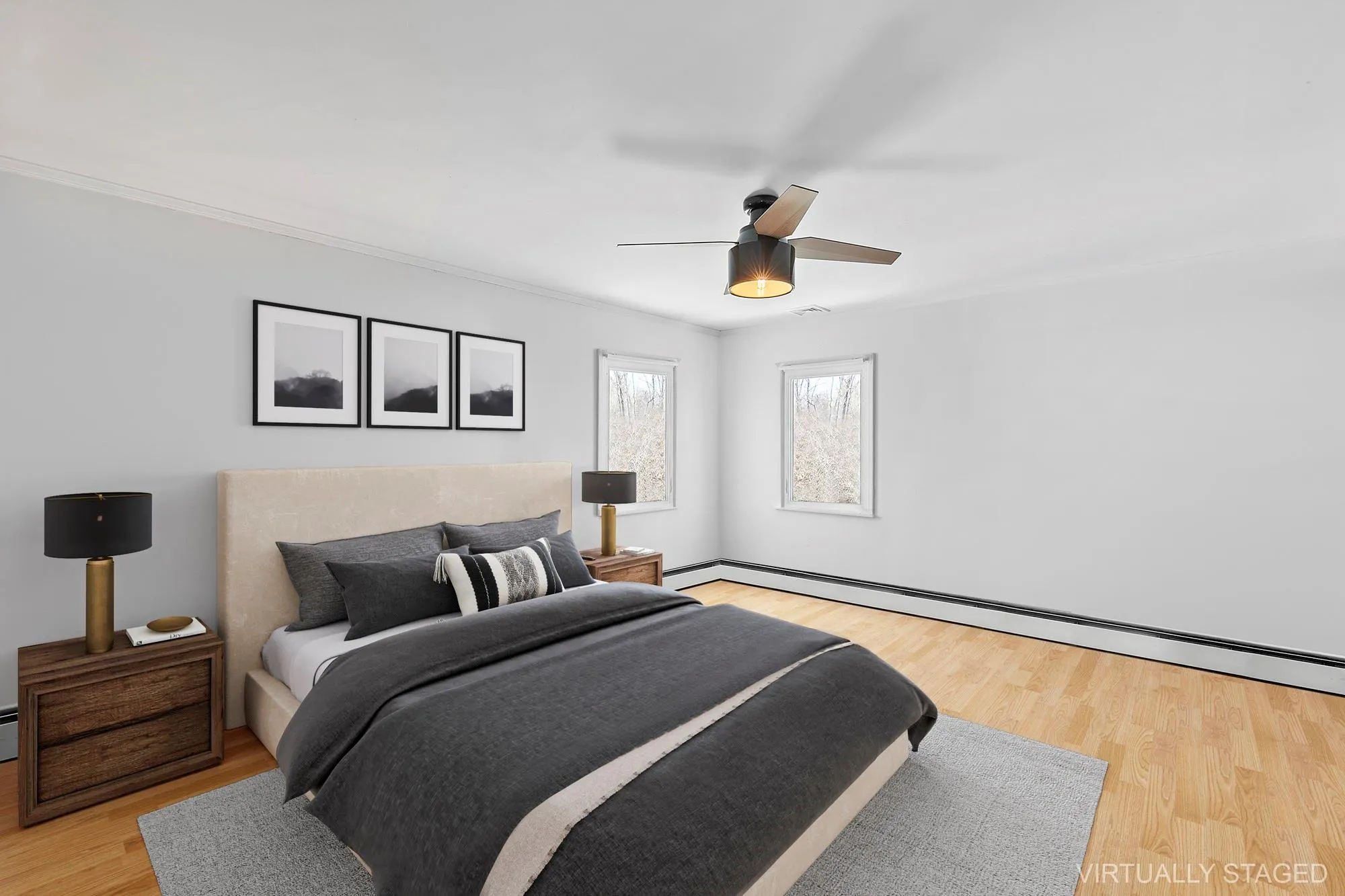 Bedroom featuring baseboard heating, a ceiling fan, crown molding, and light wood-style floors Bedroom featuring baseboard heating, a ceiling fan, crown molding, and light wood-style floors