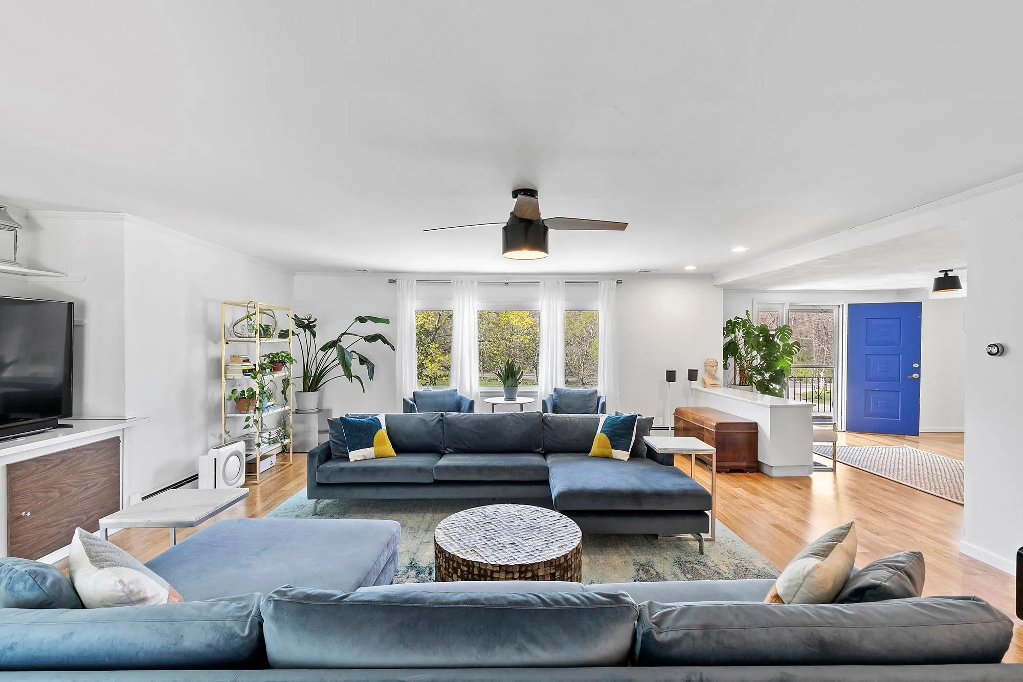Living area featuring ceiling fan, wood finished floors, and crown molding Living area featuring ceiling fan, wood finished floors, and crown molding