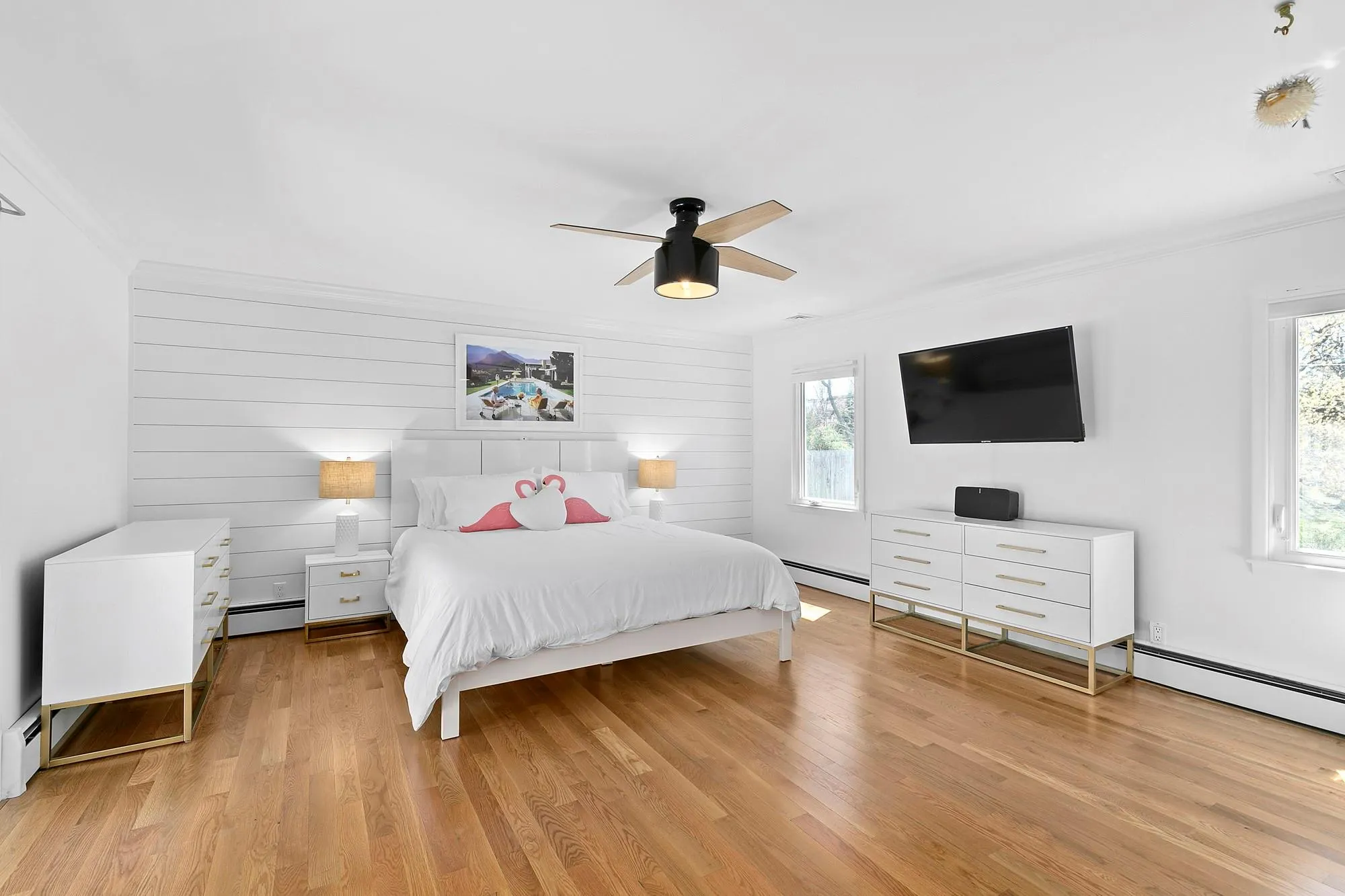 Bedroom featuring ornamental molding, a baseboard heating unit, and wood finished floors Bedroom featuring ornamental molding, a baseboard heating unit, and wood finished floors