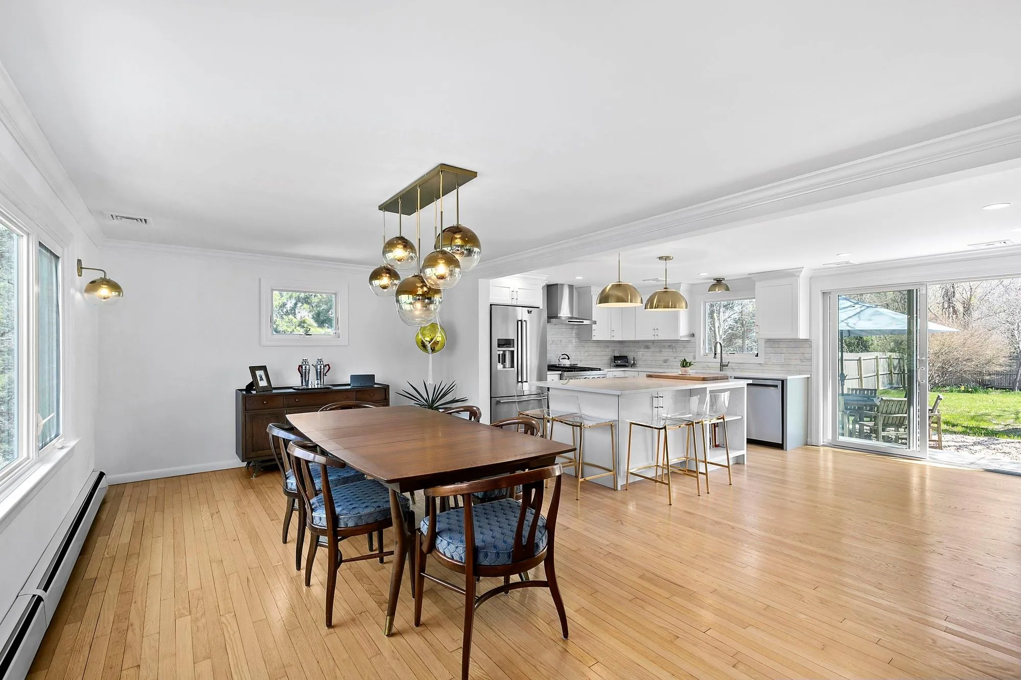 Dining space with baseboards, visible vents, light wood-style flooring, ornamental molding, and a baseboard heating unit Dining space with baseboards, visible vents, light wood-style flooring, ornamental molding, and a baseboard heating unit